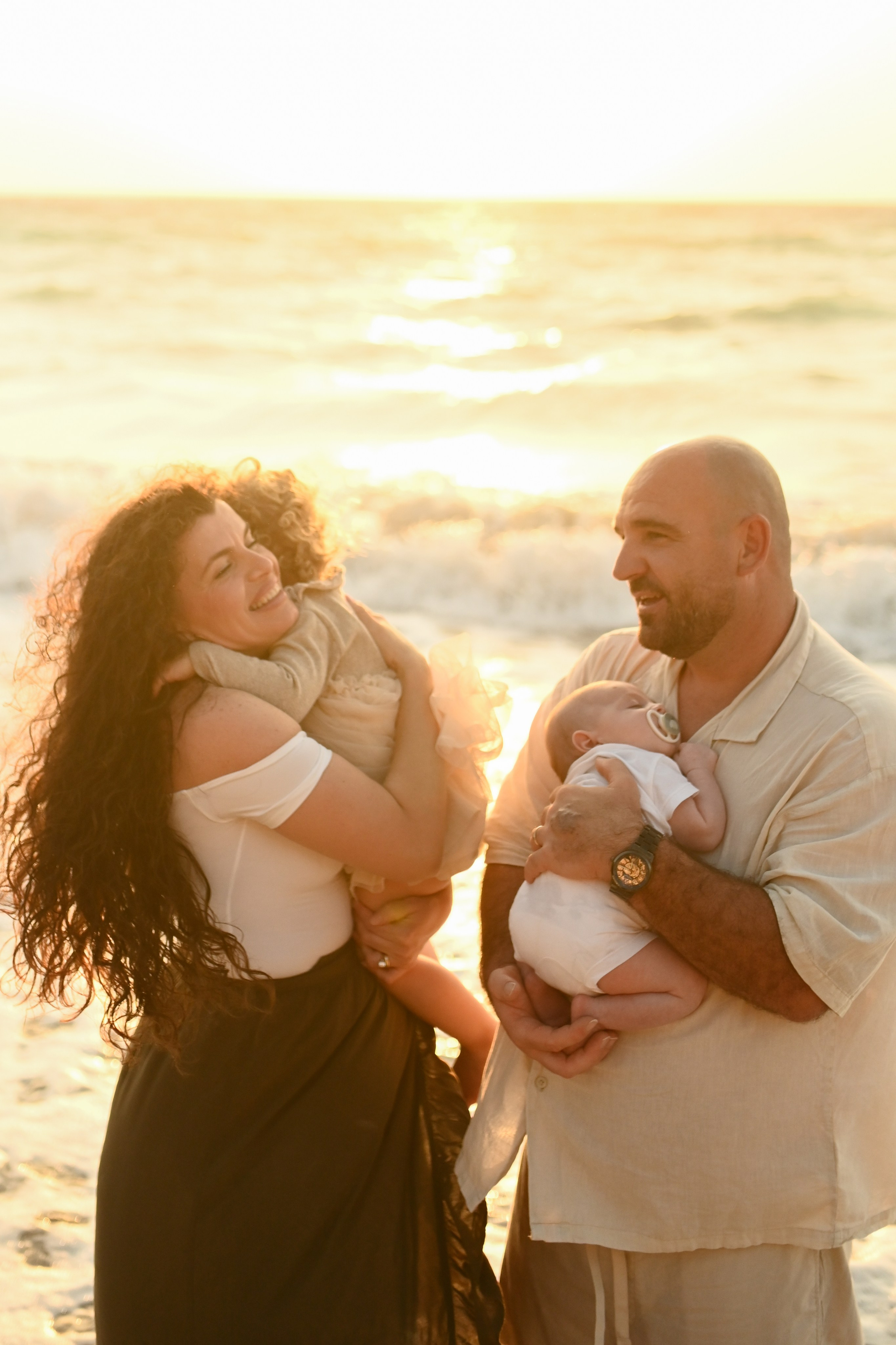 Happy family walking along a Rhodes beach at sunset. Photographer in Rhodes Island