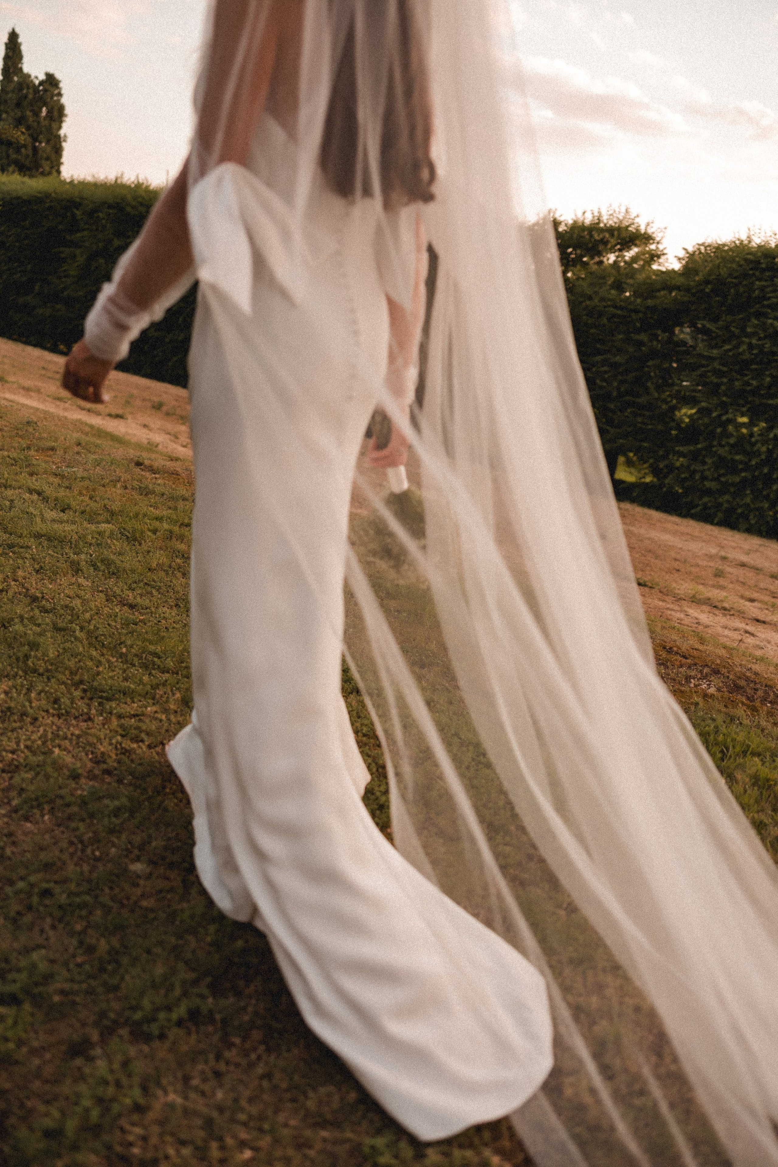 Close-up do vestido de noiva e véu fluido, elegância minimalista com luz natural