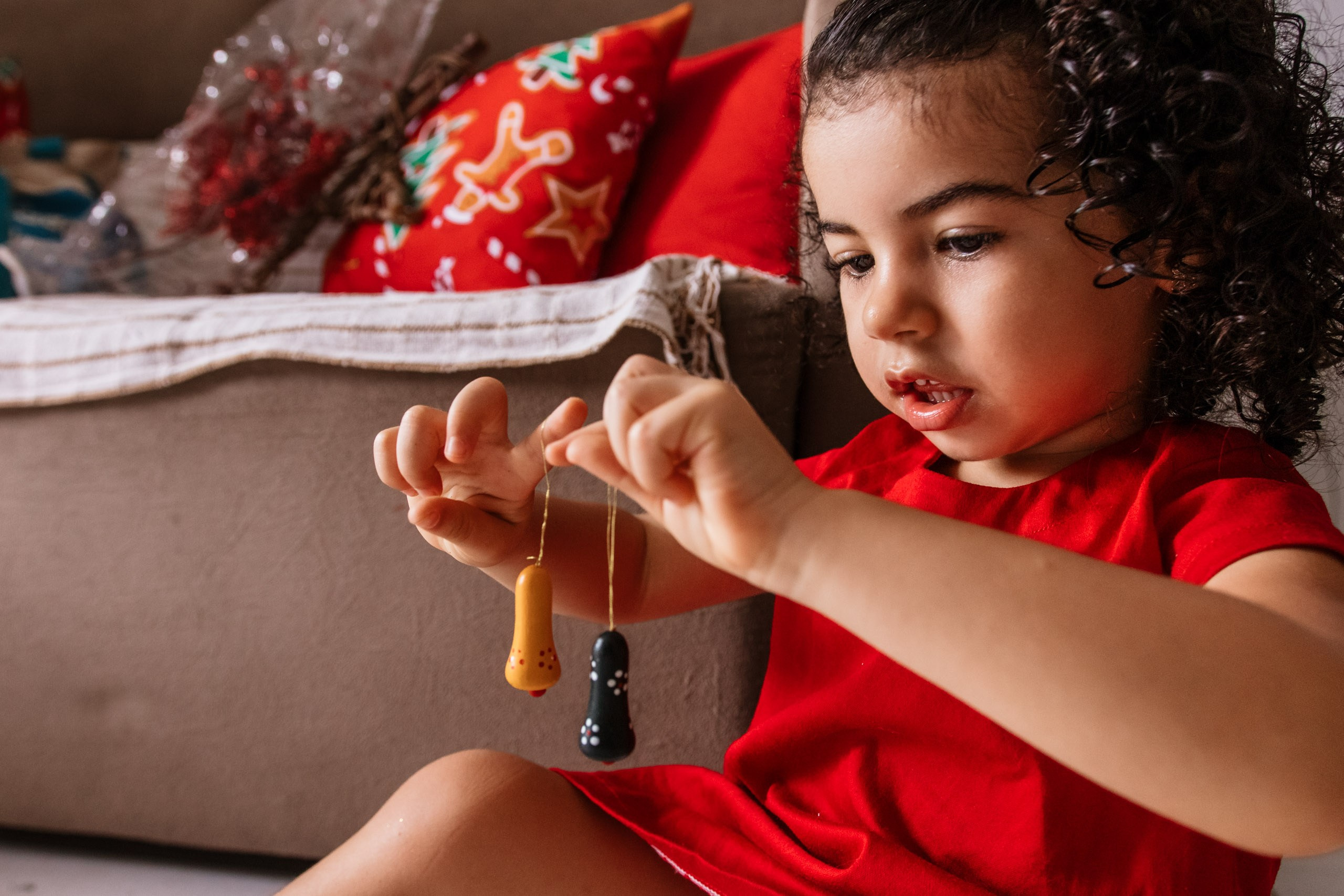 menina brincando com enfeites de natal