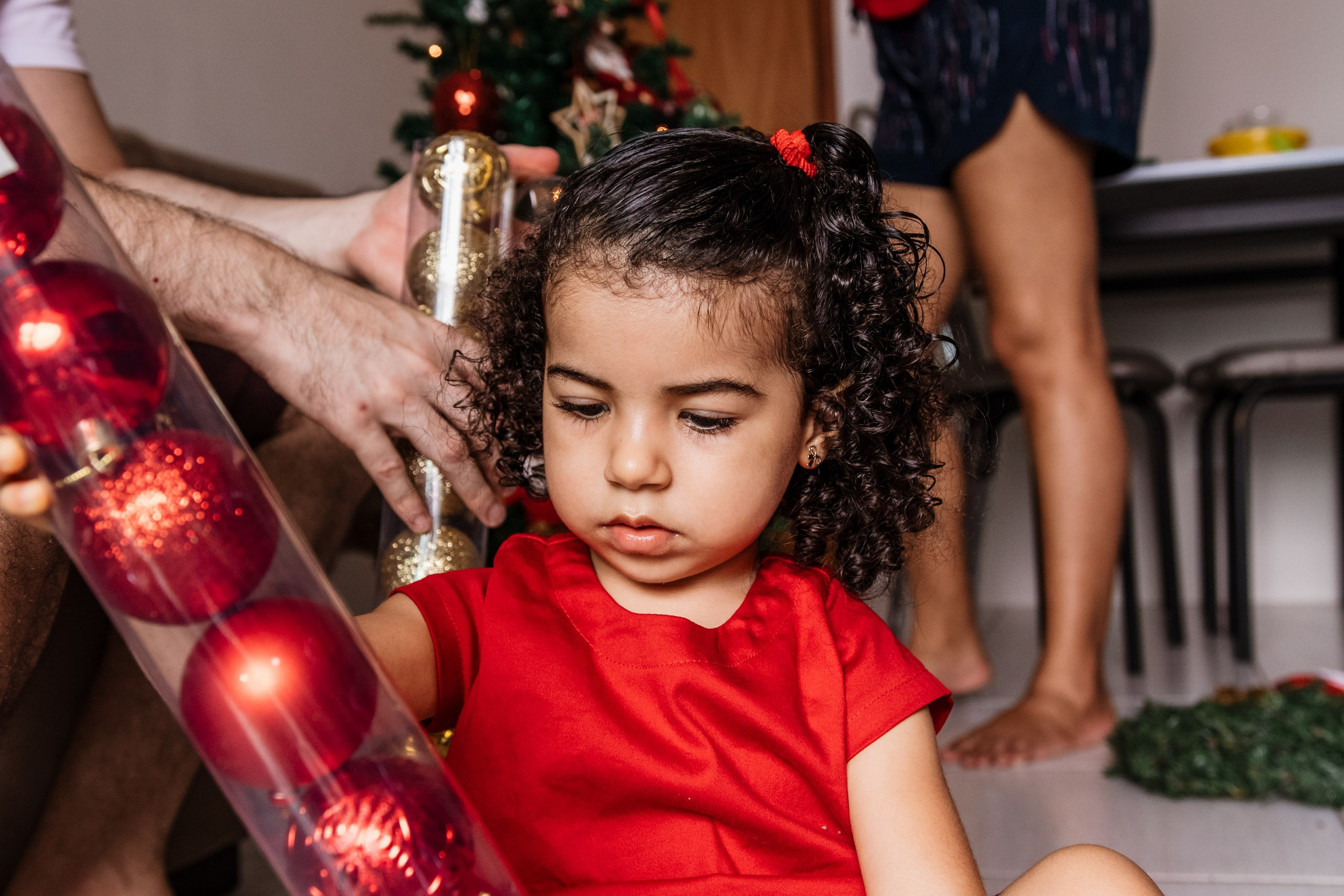 menina brincando com enfeites de natal
