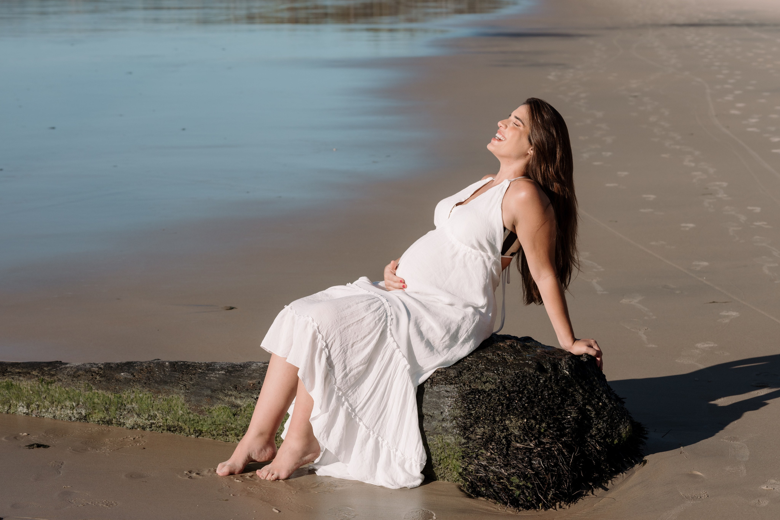 Gestante em ensaio ao amanhecer na praia