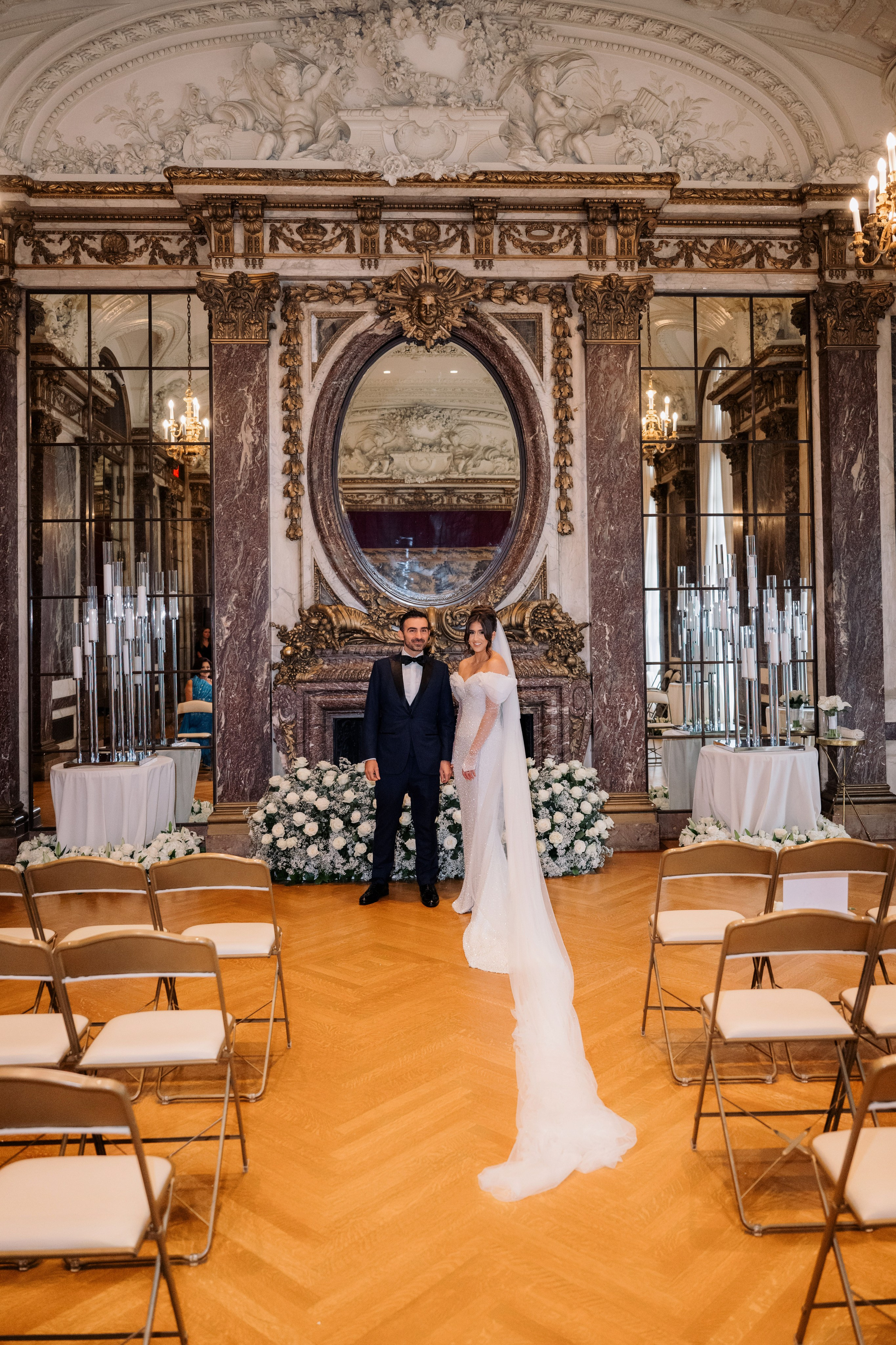a bride and groom standing in a room with chairs