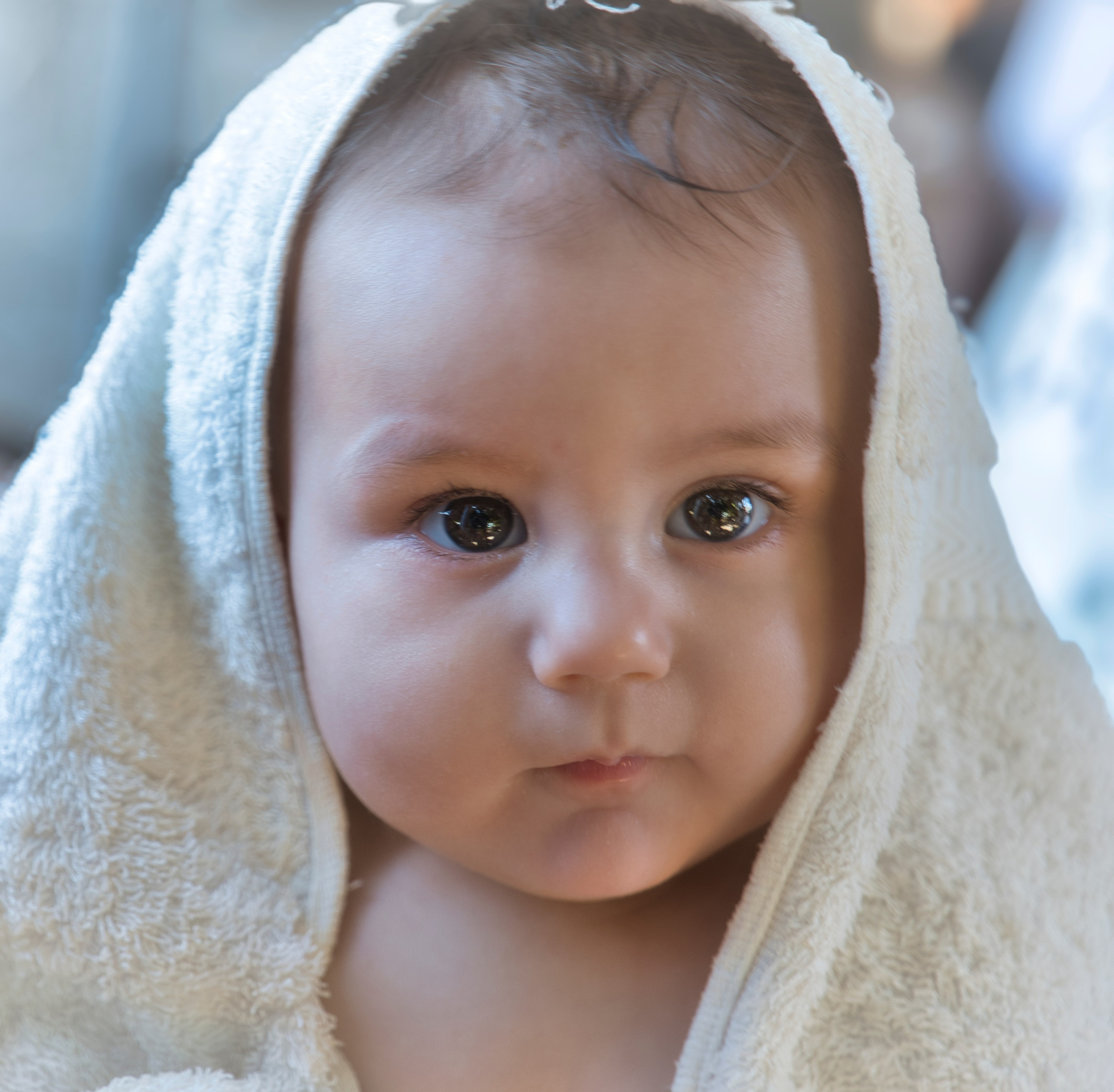 Bebé envuelto en una toalla blanca después del baño.
