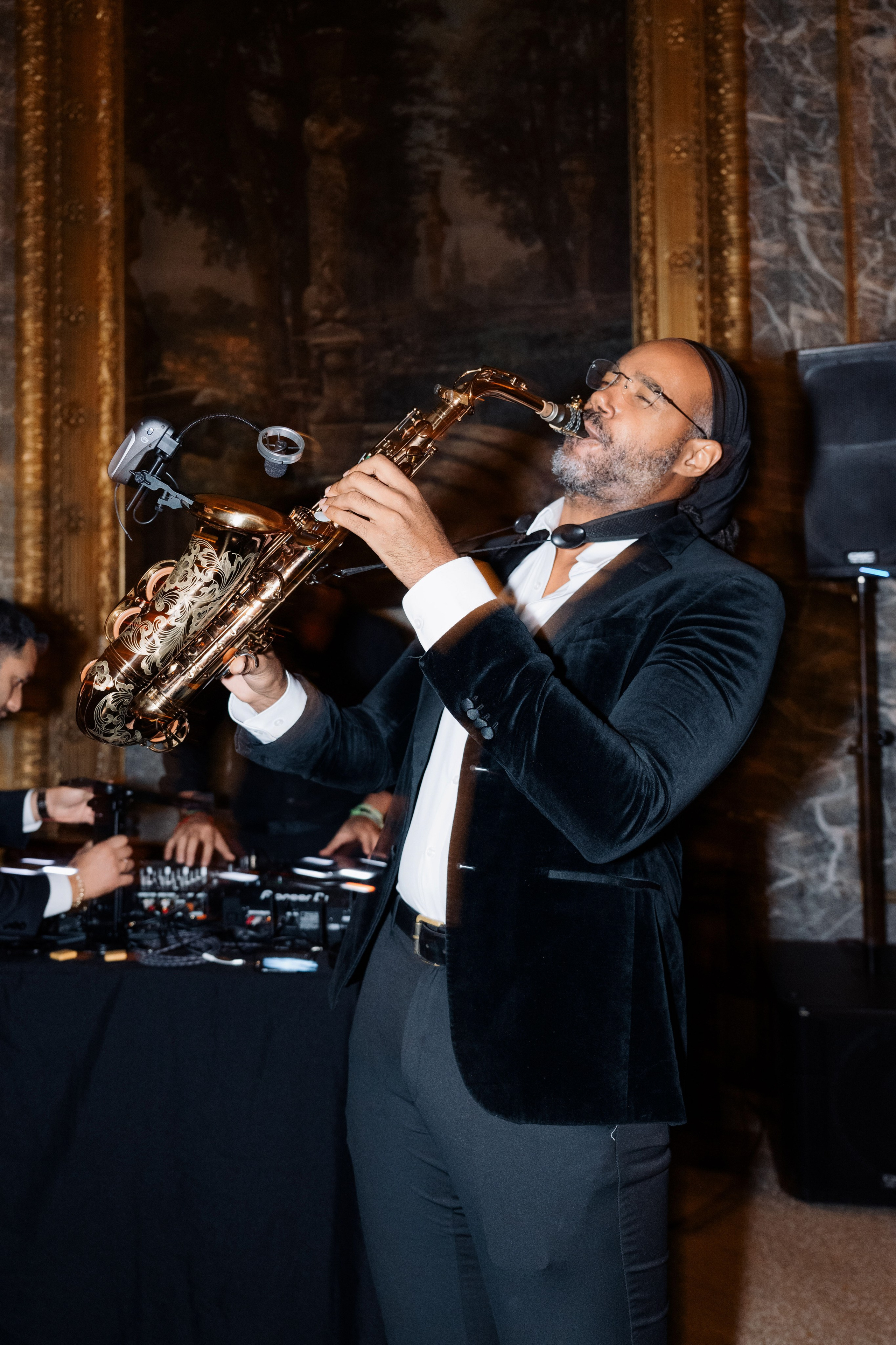 a man in a tuxed suit playing a saxophone