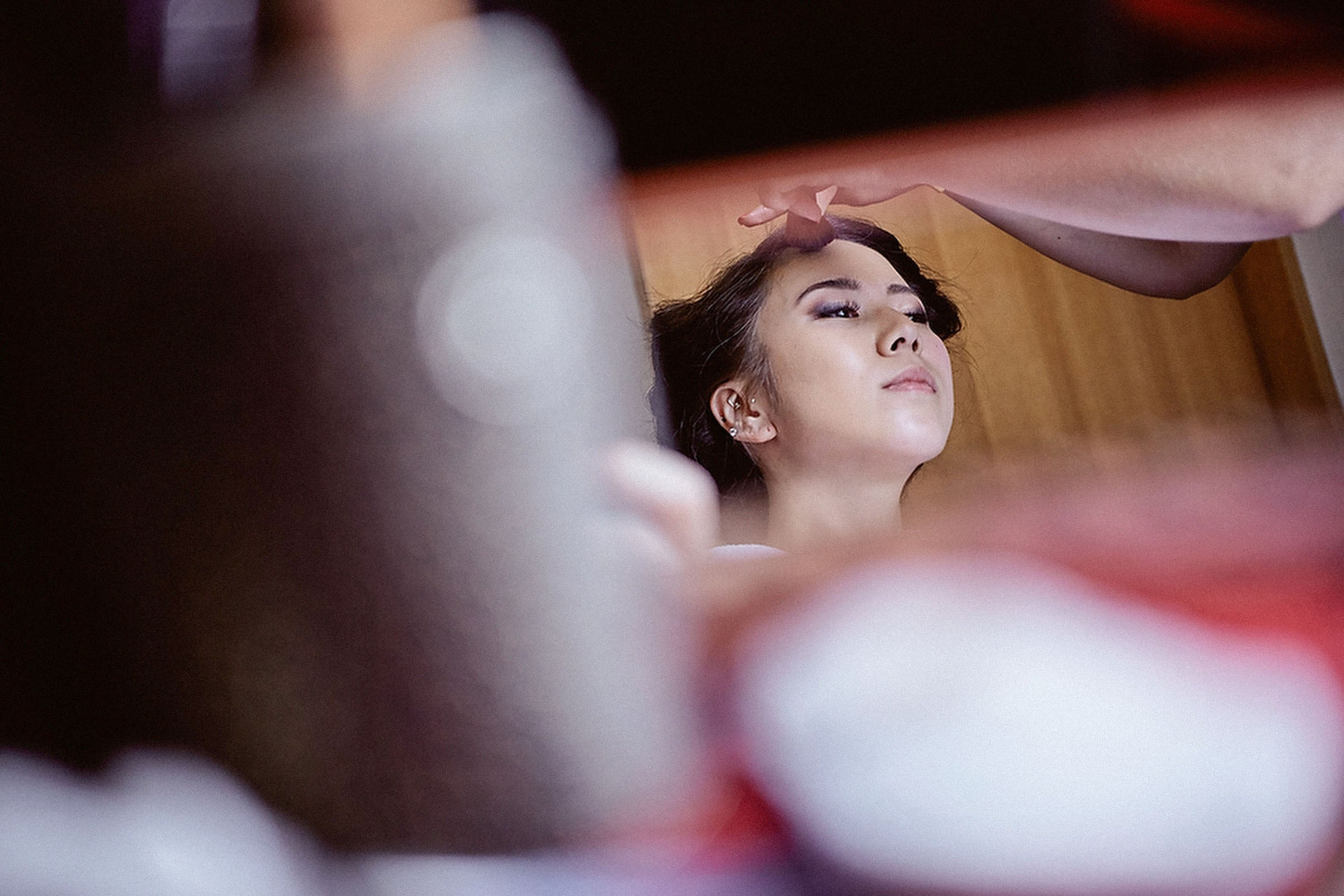 Bride sits patiently as her hair and makeup creates her visage for her wedding day.