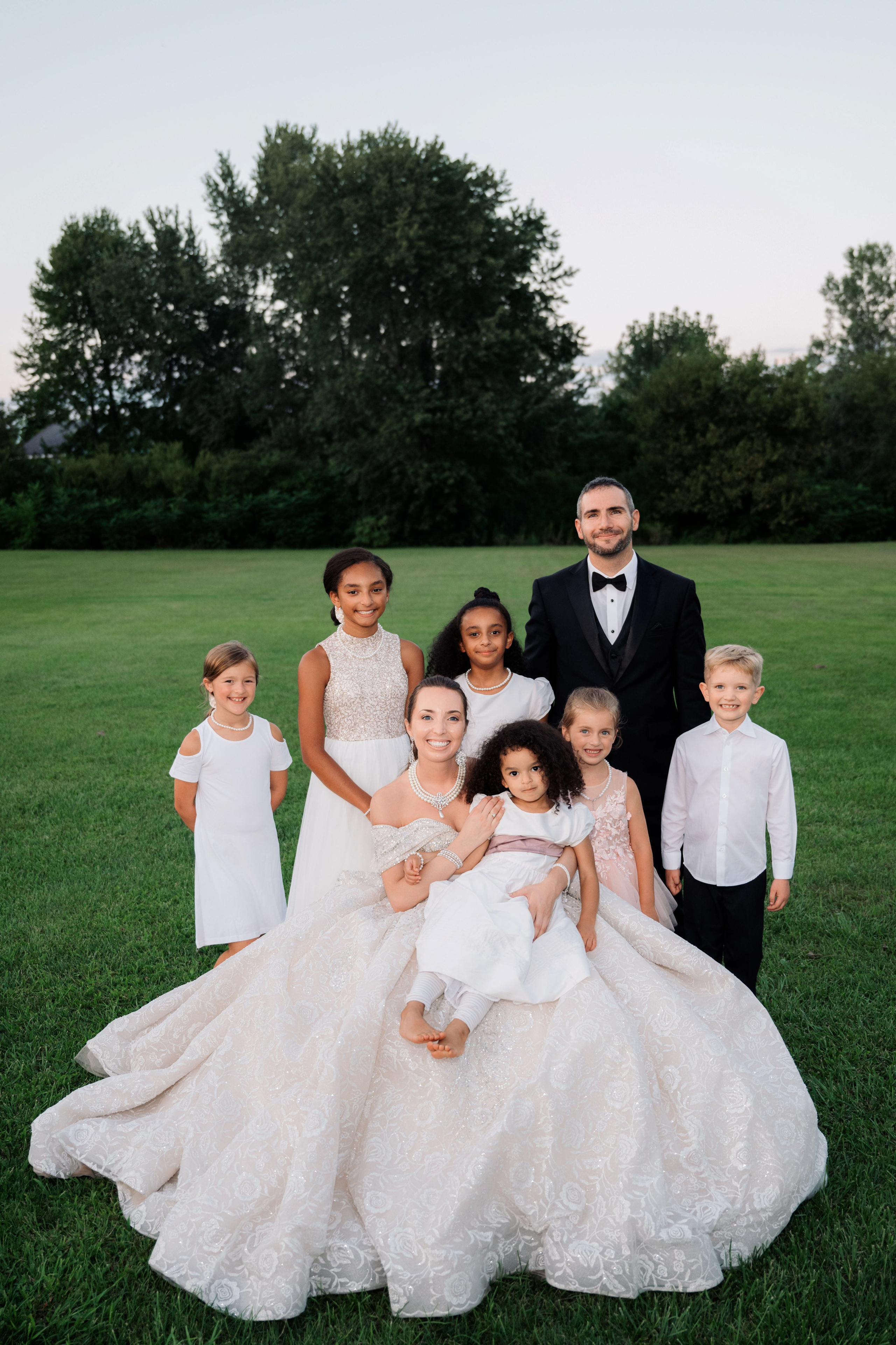 a family poses for a photo in the grass