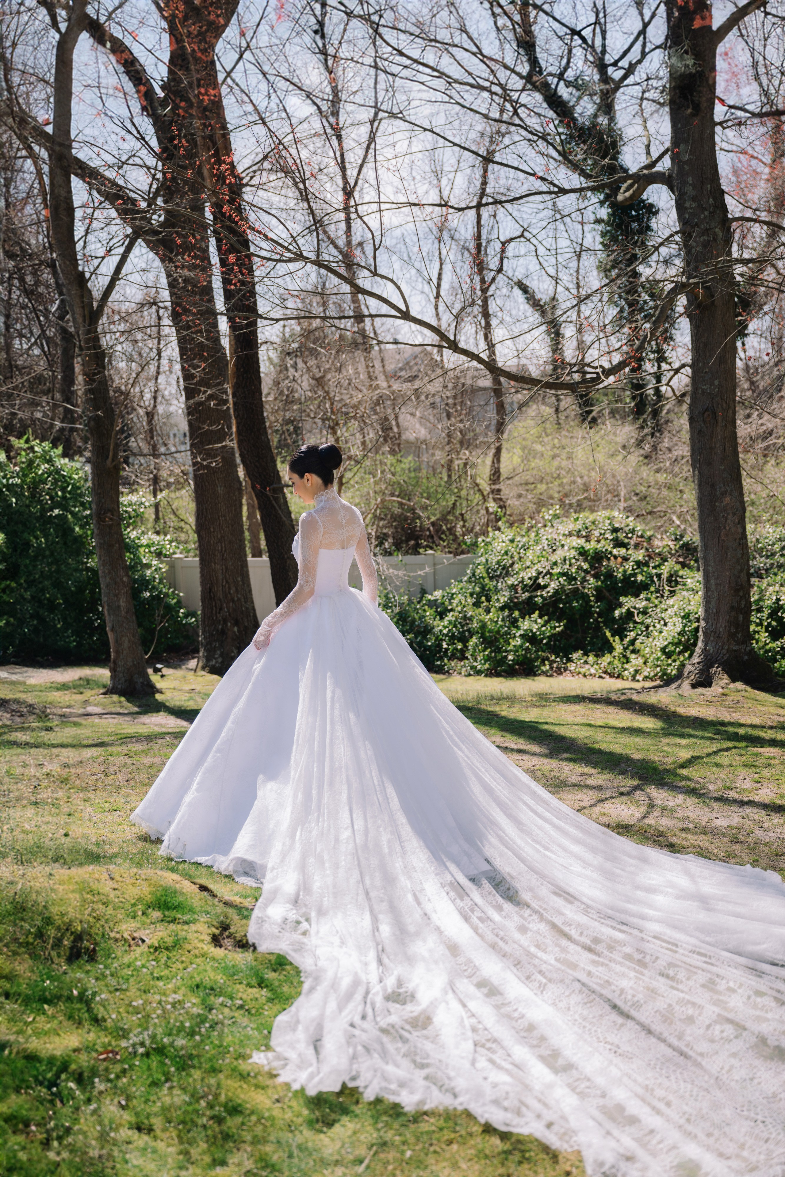 a bride in a white wedding dress standing in the grass