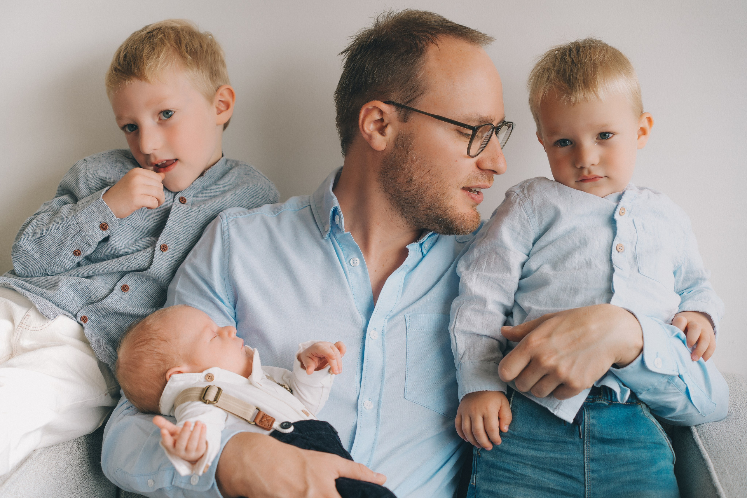 Father sitting with two children during a relaxed family photo session, natural light photography Solihull