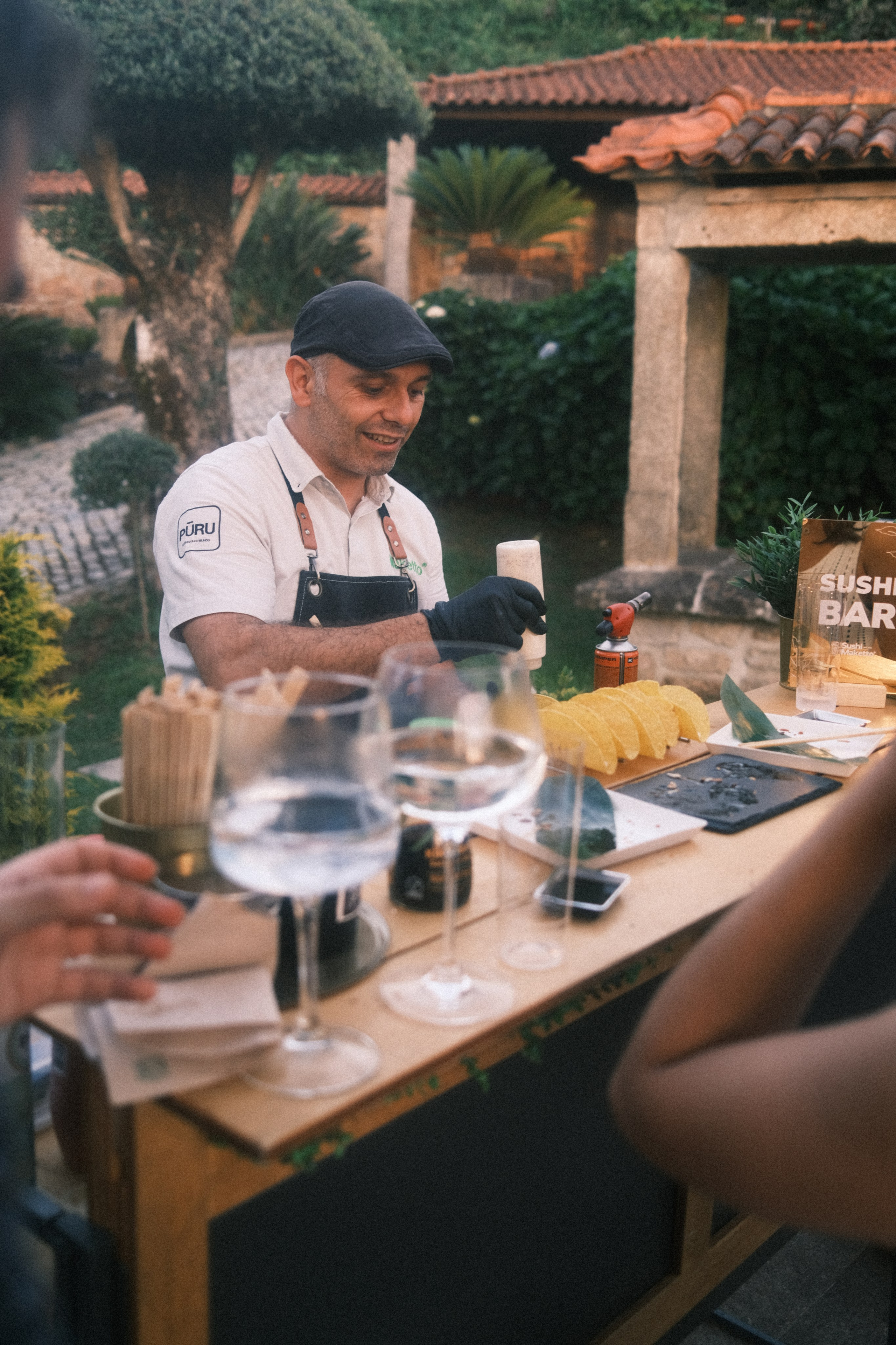 Fotografia de eventos de um bartender a preparar e a servir bebidas aos convidados no bar ao ar livre, captada pela Khave Media