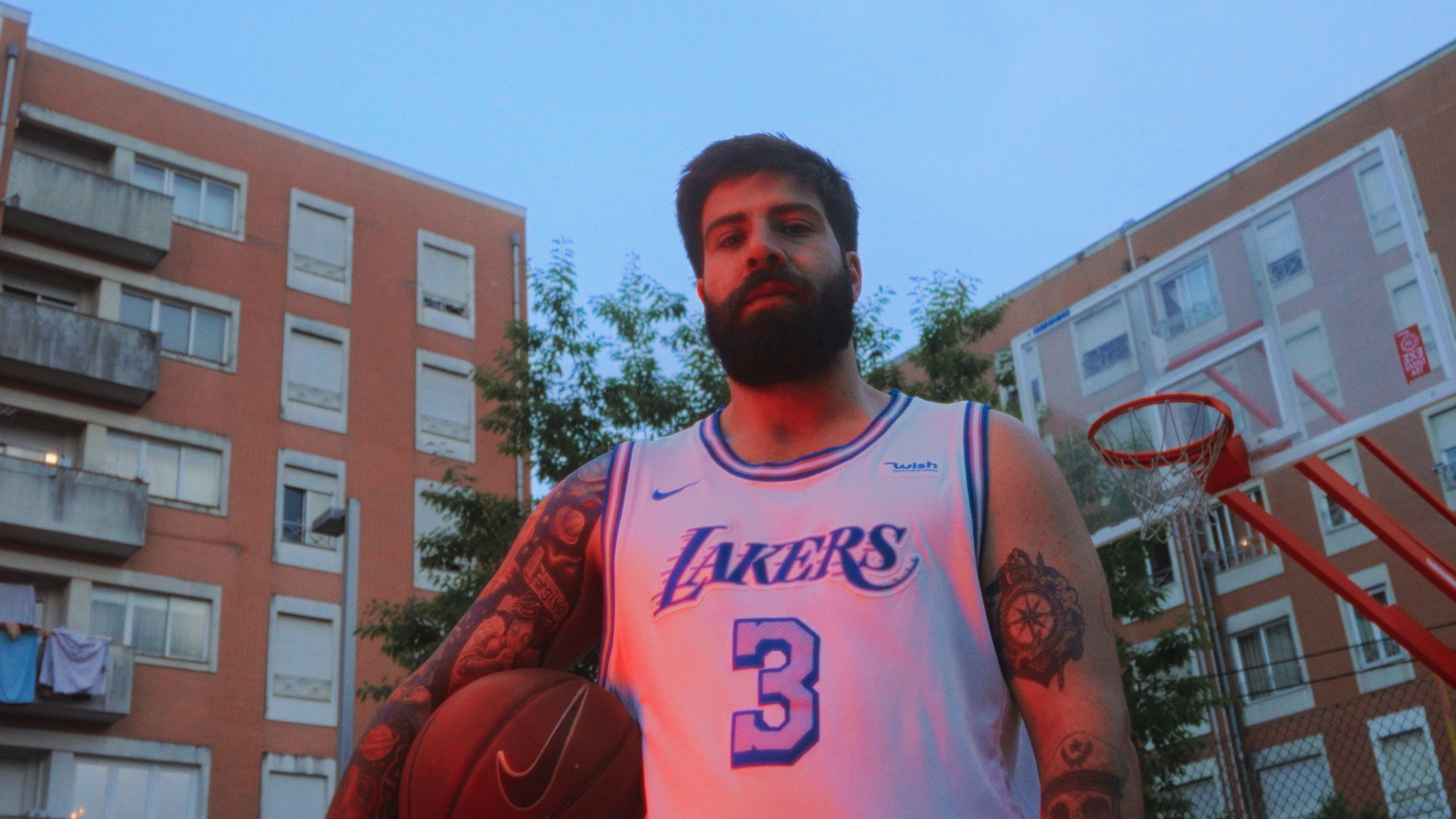Fotografia de retrato urbano de um jogador de basquetebol com a bola na mão num campo de rua, captada no norte de Portugal pela Khave Media