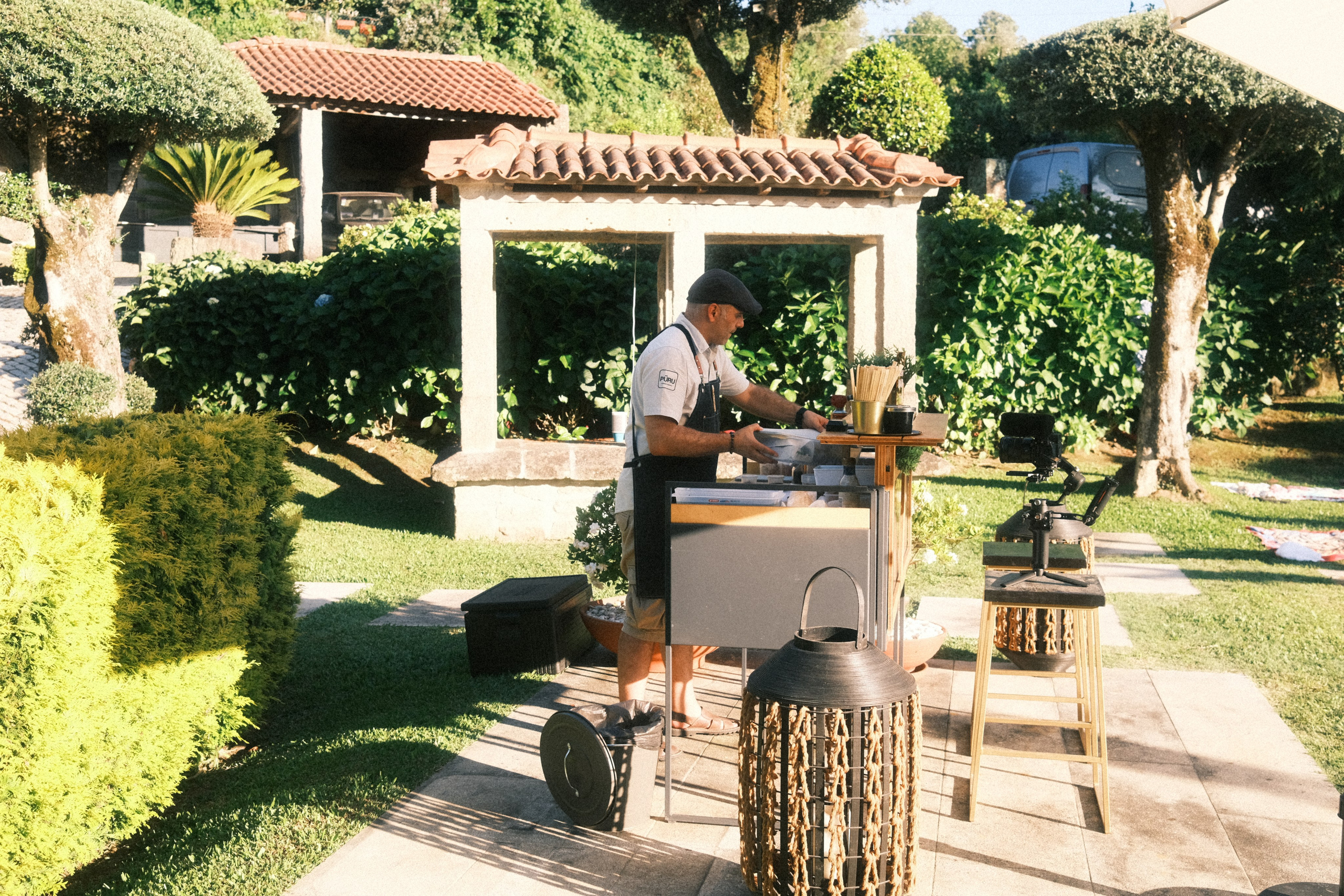 Fotografia de eventos ao ar livre mostrando a preparação de um serviço de bar num jardim privativo, produzida no norte de Portugal pela Khave Media