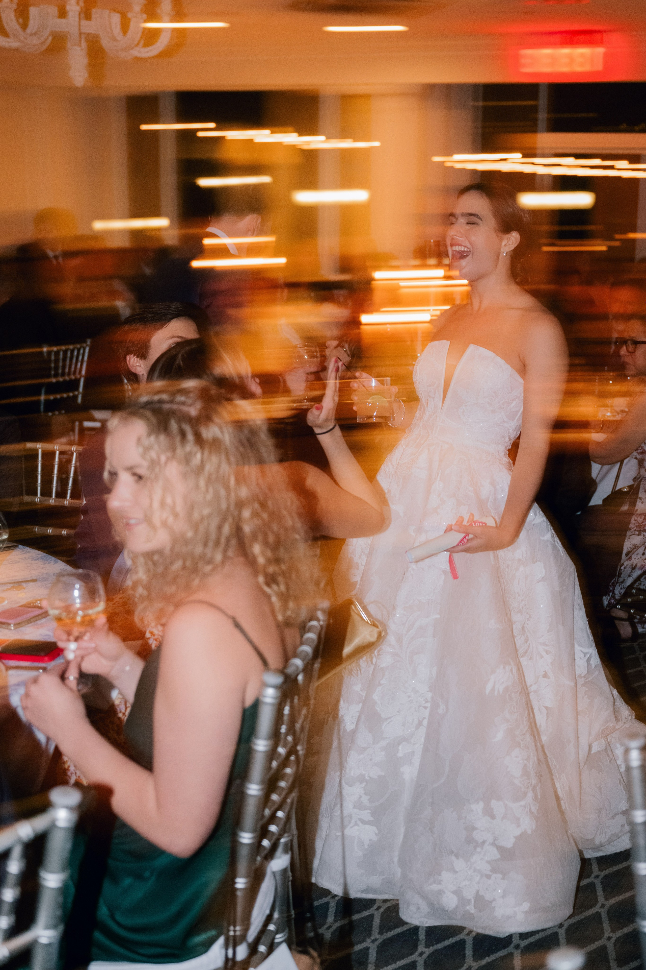 a woman in a wedding dress is sitting at a table