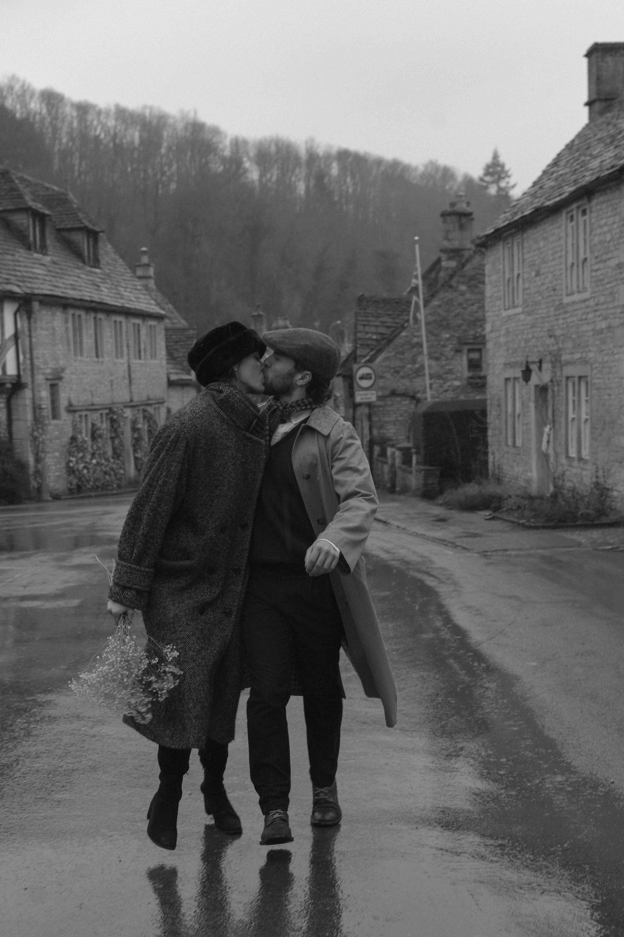 romantic couple running together and kissing in rainy countryside with soft motion blur UK photoshoot