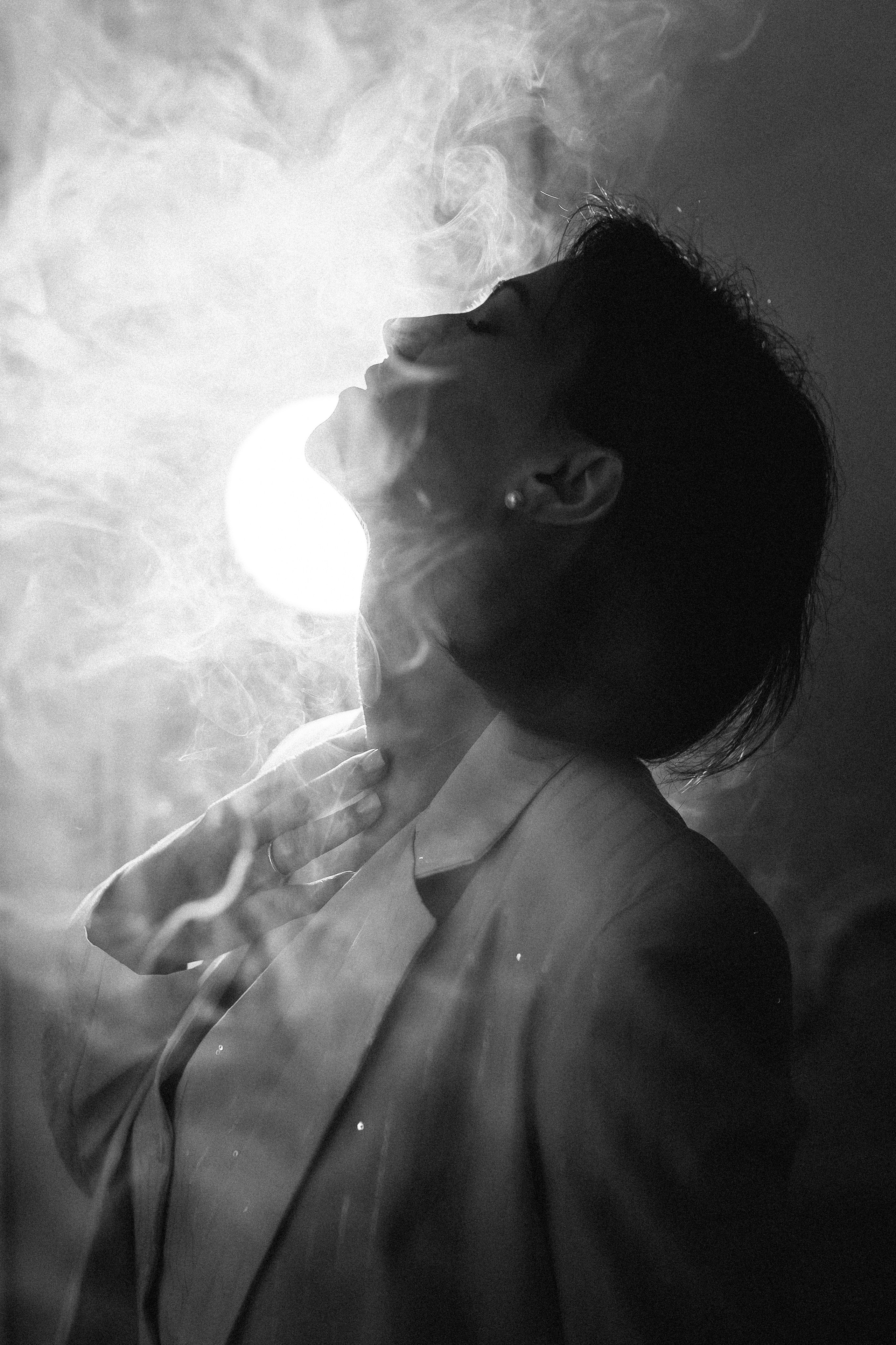Frauenporträt in einem künstlerischen Stil, umgeben von sanftem Rauch
