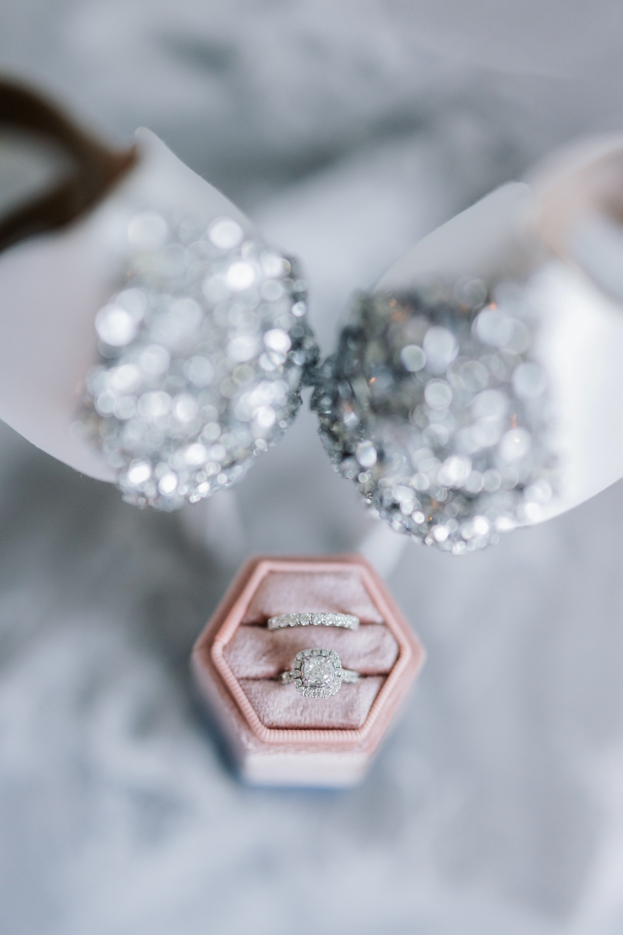 a diamond ring sits in a pink box