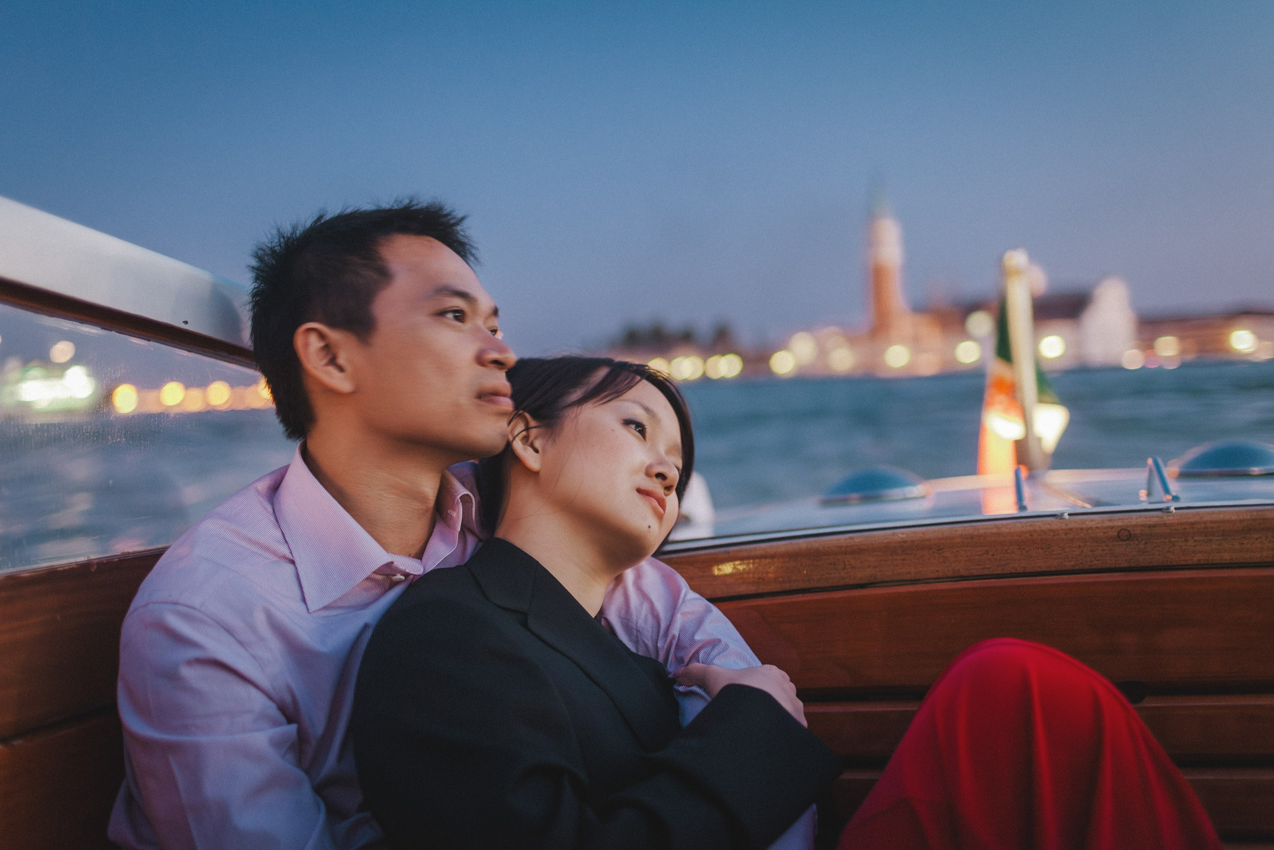 A Thai man holds his fiancee on board a private boat as they watch the sunset over the skyline of Venice.