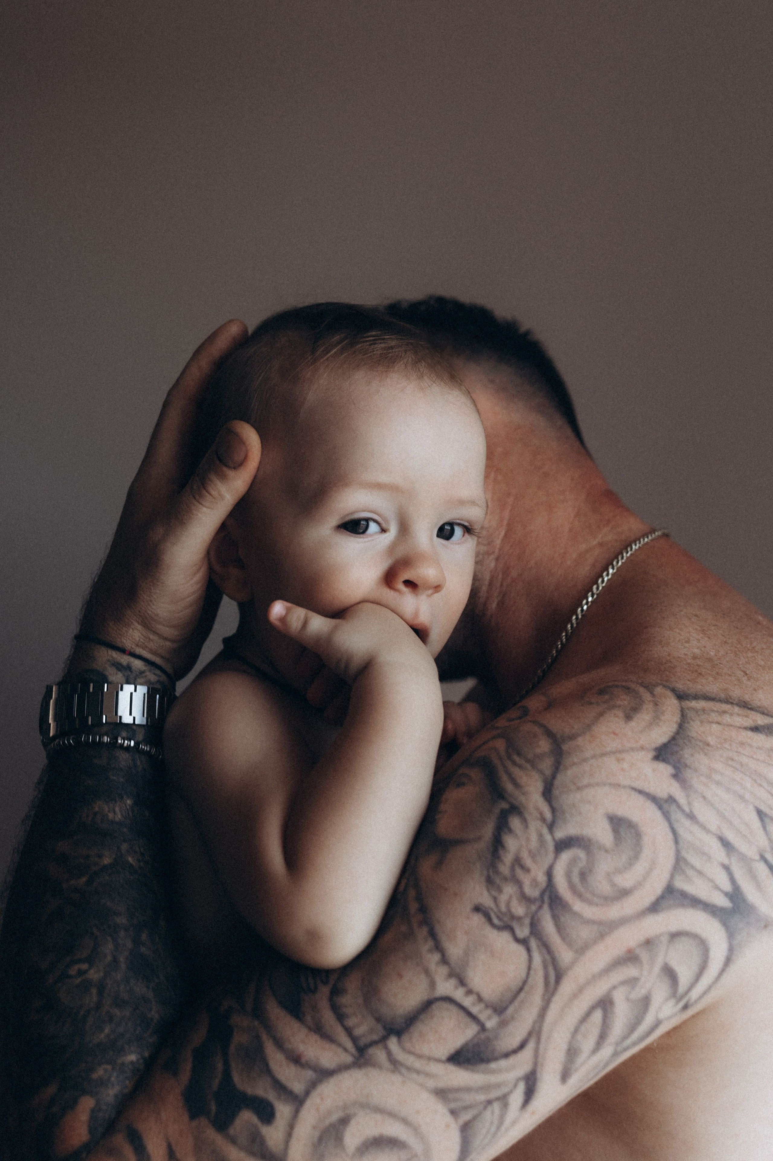 Servizio fotografico di famiglia a San Marino: ritratto intimo di un padre con il suo bambino, momento di connessione e protezione, luce naturale, fotografia familiare autentica