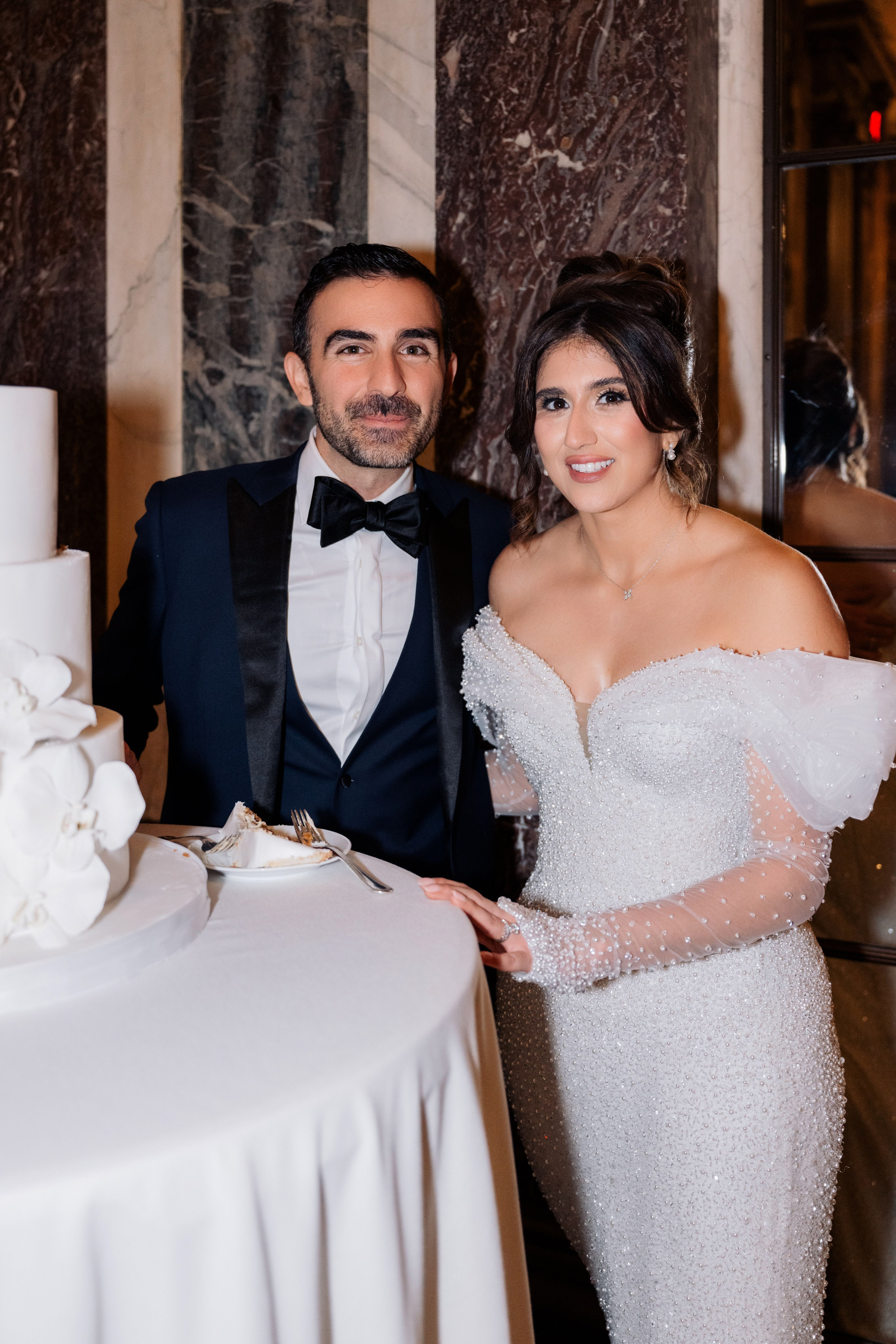 a man and woman standing next to a cake