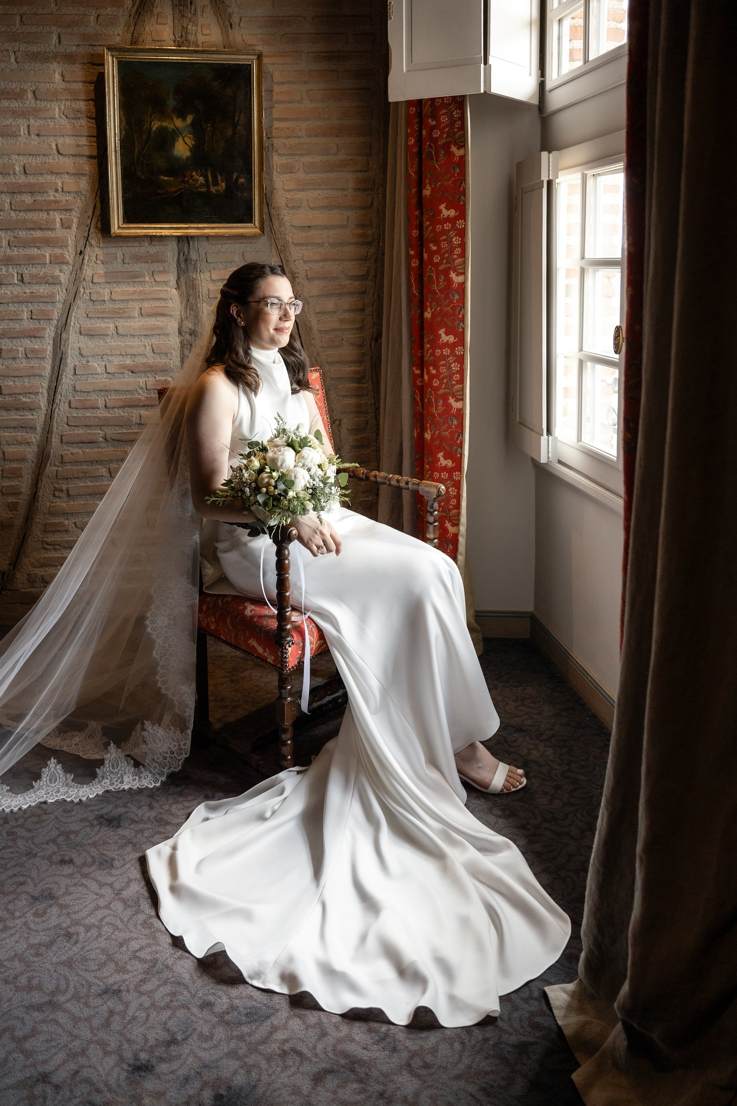 Bridal portrait through a stone window at Château Mercuès