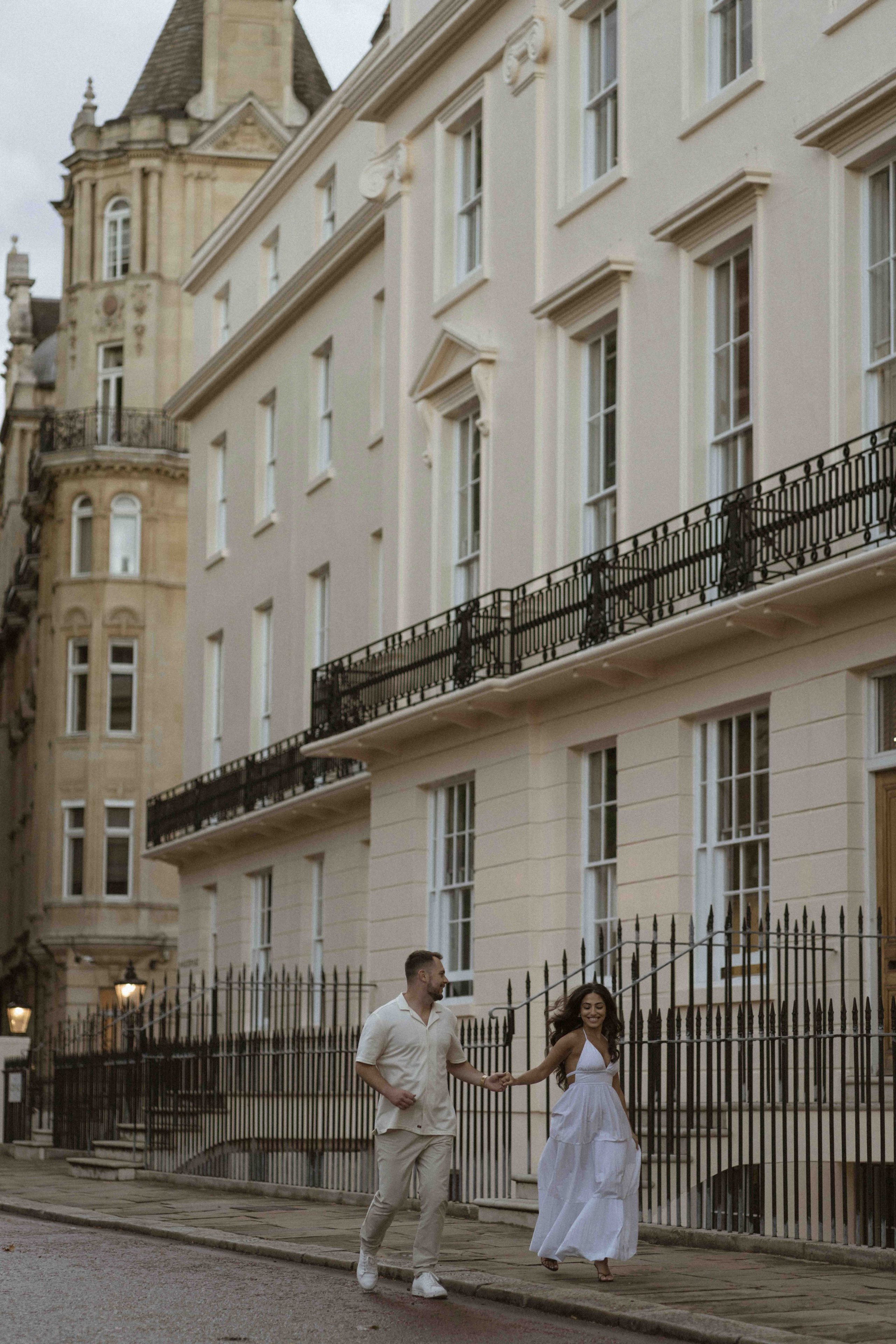 Couple walking in London street after proposal, engagement photos with city architecture