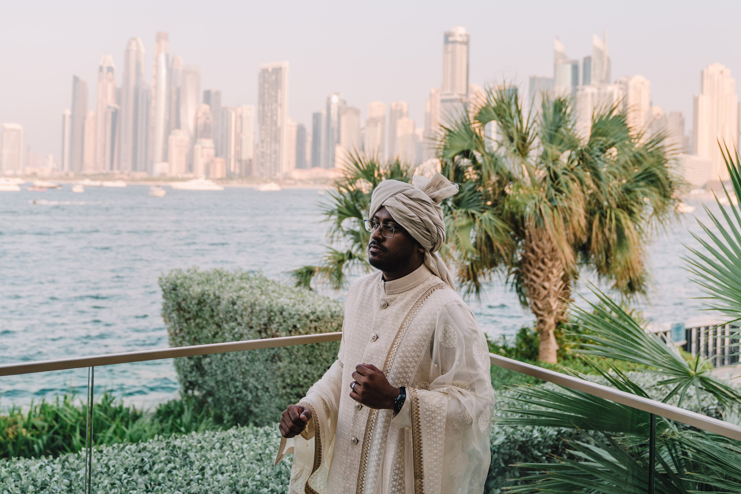 Indian groom in a national dress posing with Dubai scenery on a background