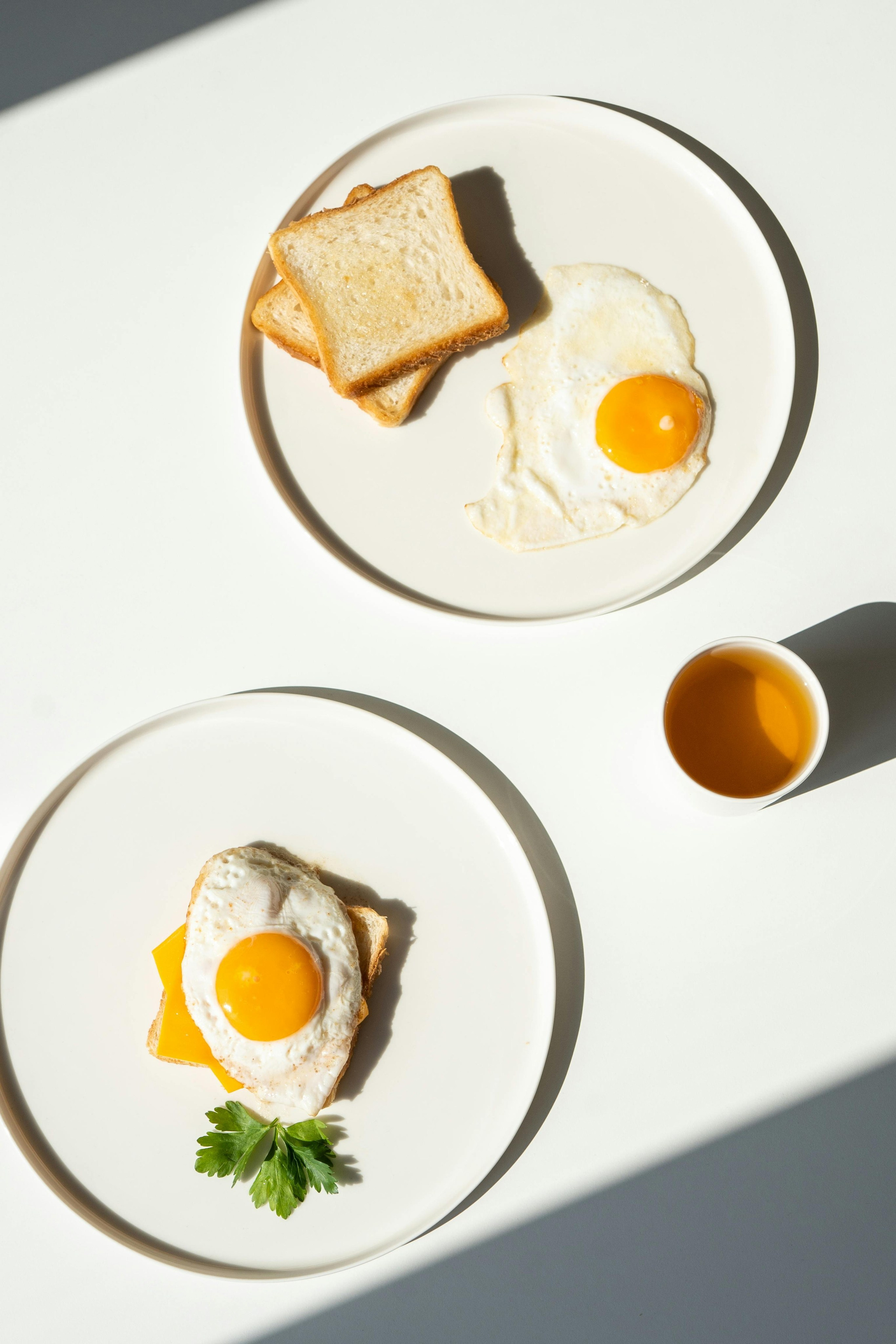 Lifestyle food photography of modern breakfast plate with eggs and toast on neutral background by Jay Soundo