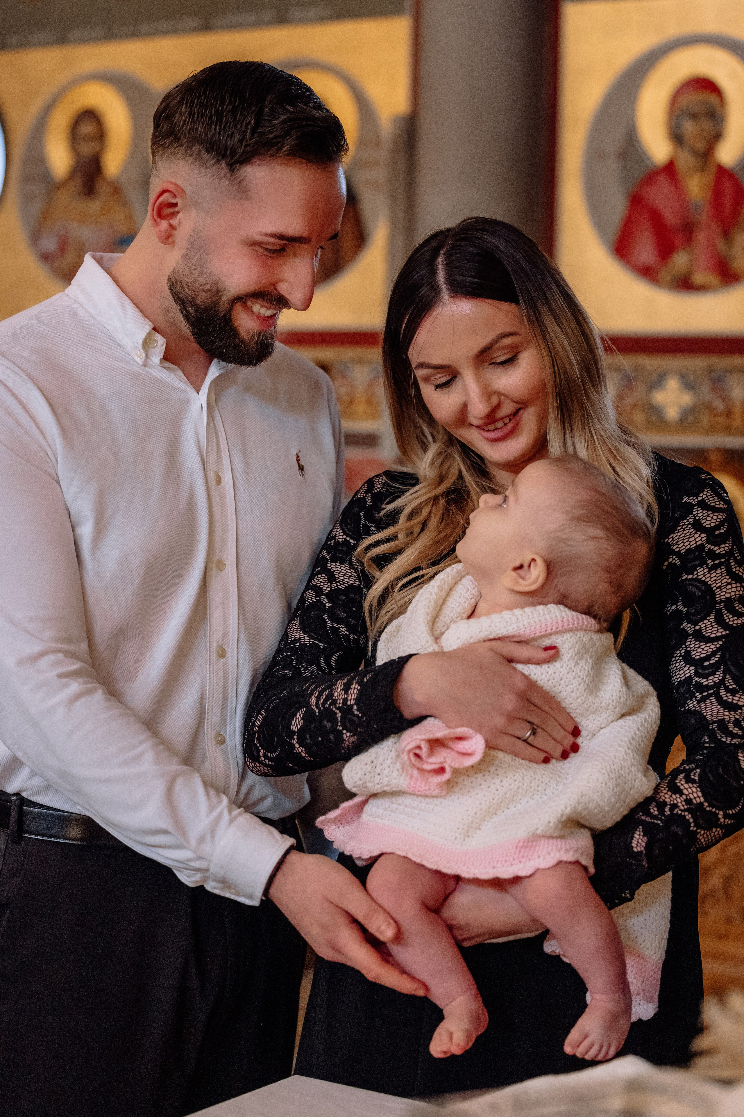 Eltern halten Baby während der Taufe – emotionale Momente Allach