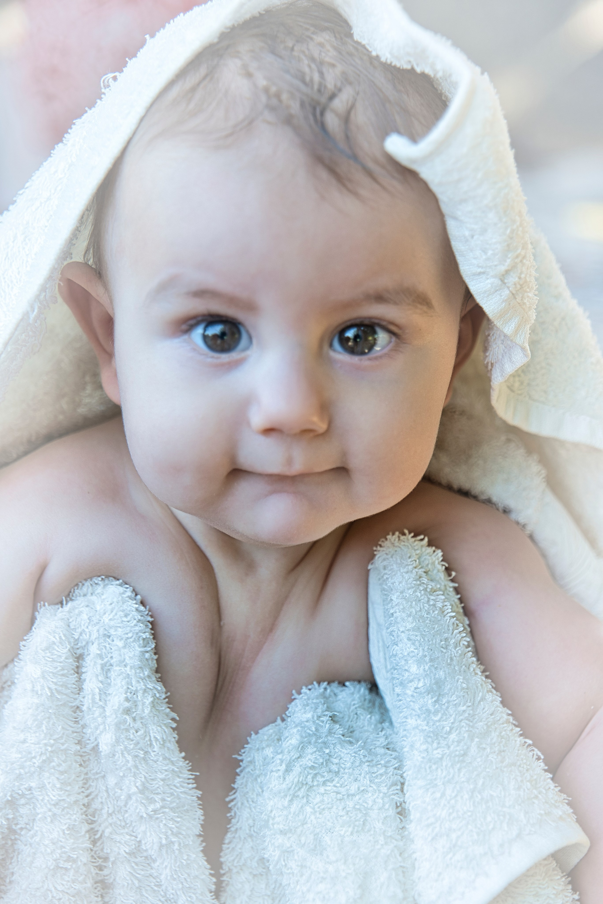 Bebé envuelto en una toalla blanca después del baño.