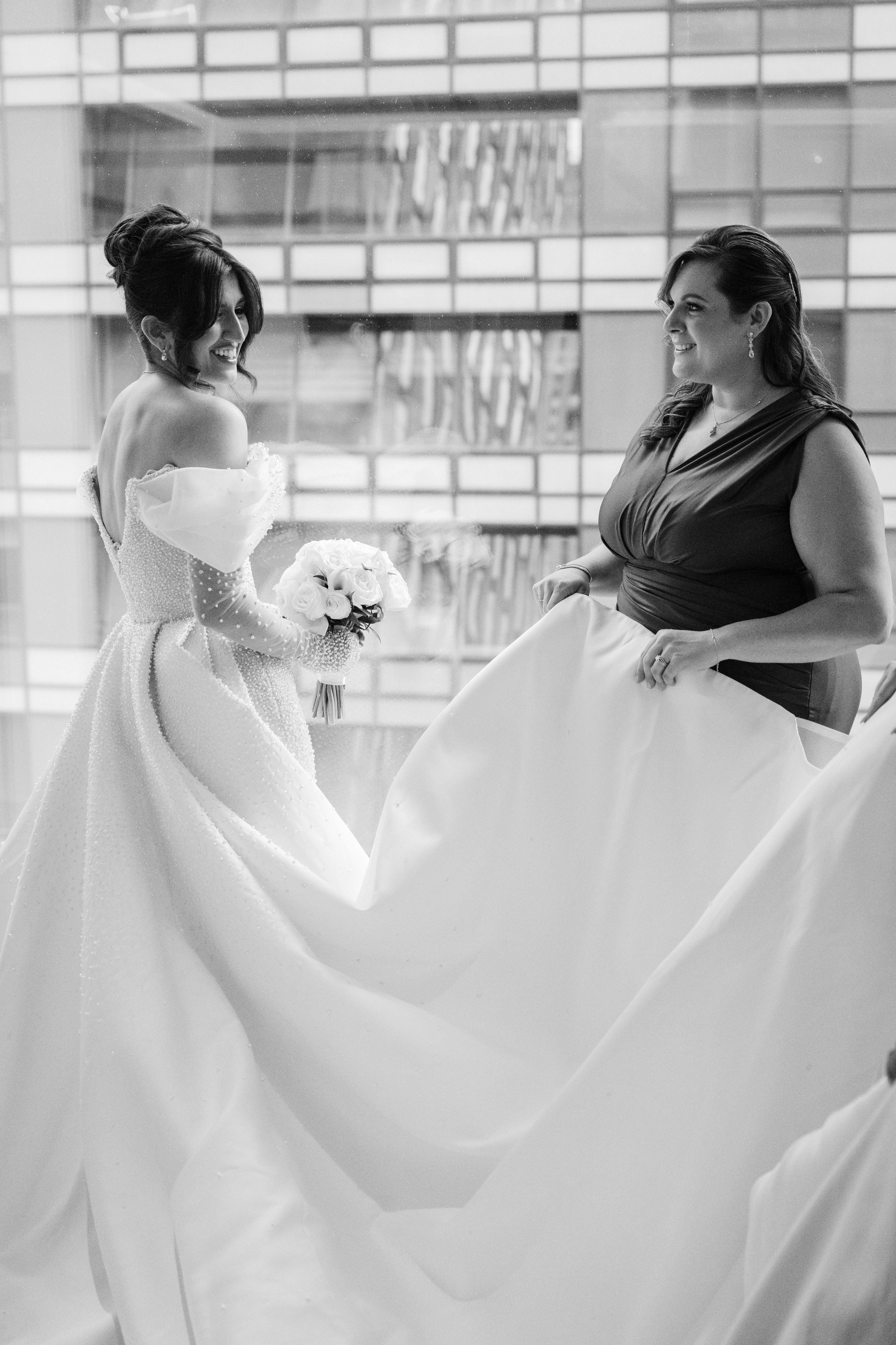 a bride and her maid look at each other brides in the window