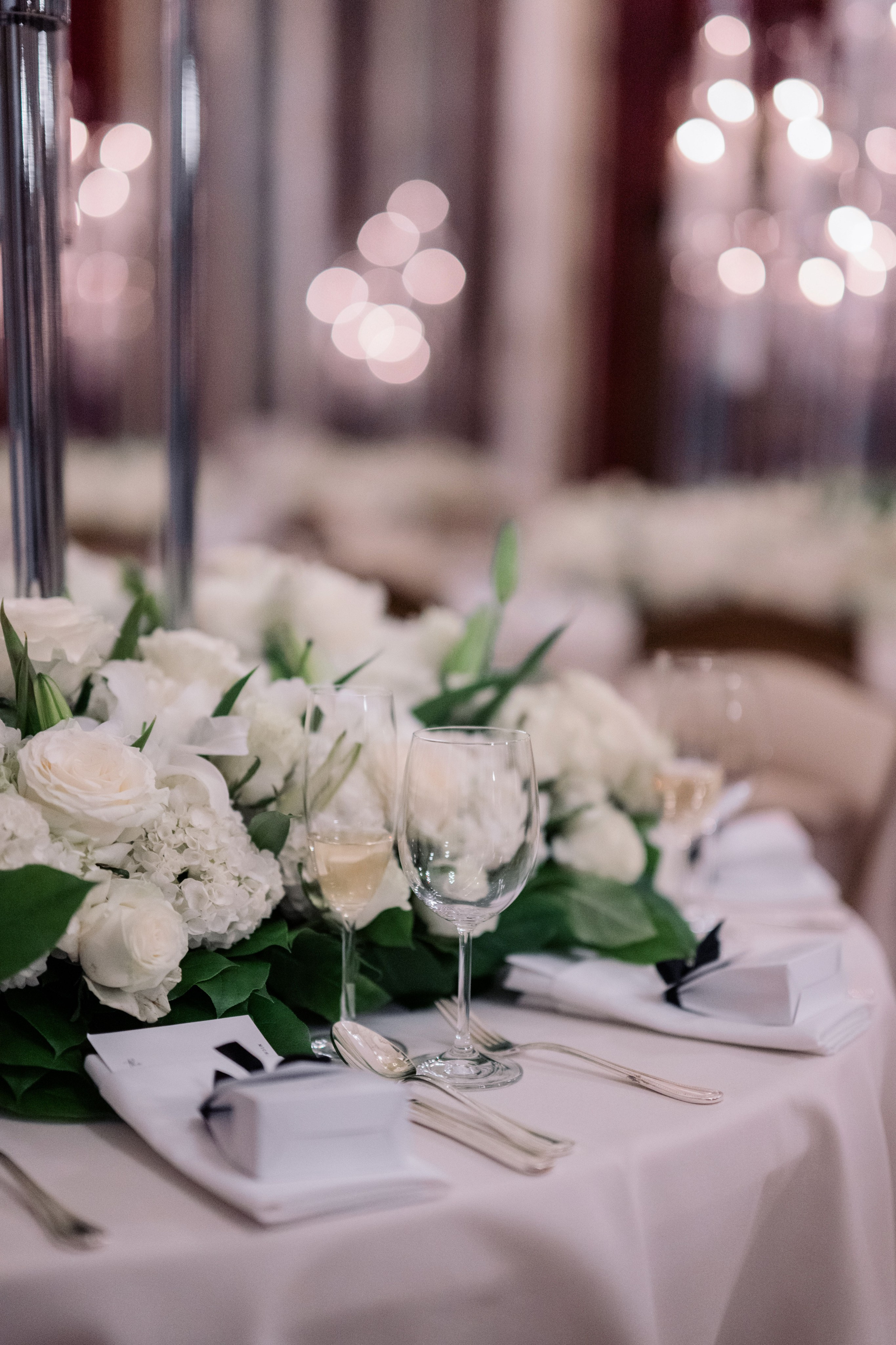 a table with white flowers and silverware