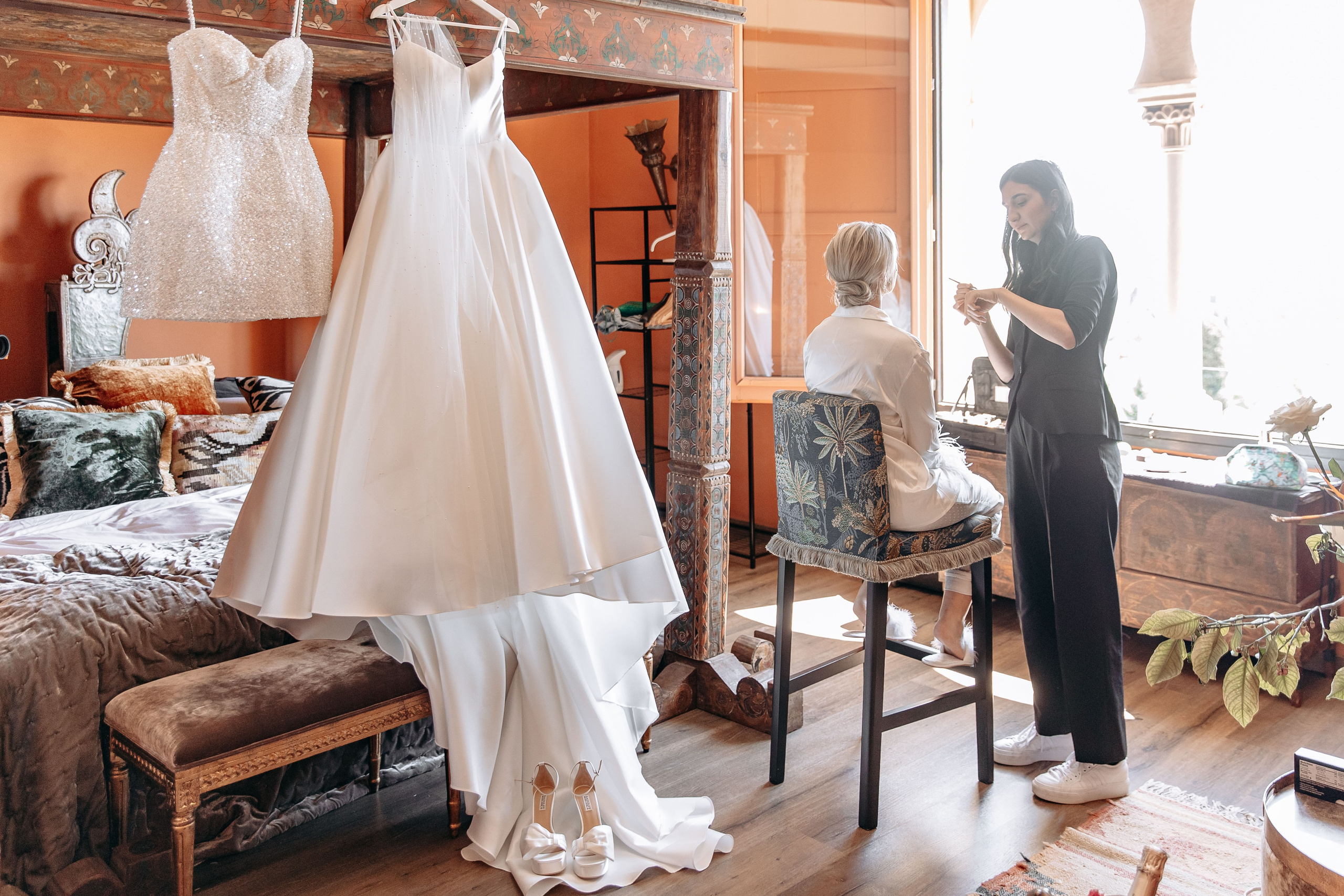 Bride getting ready in a room at Gran Villa Rosa, surrounded by her bridesmaids and floral arrangements.