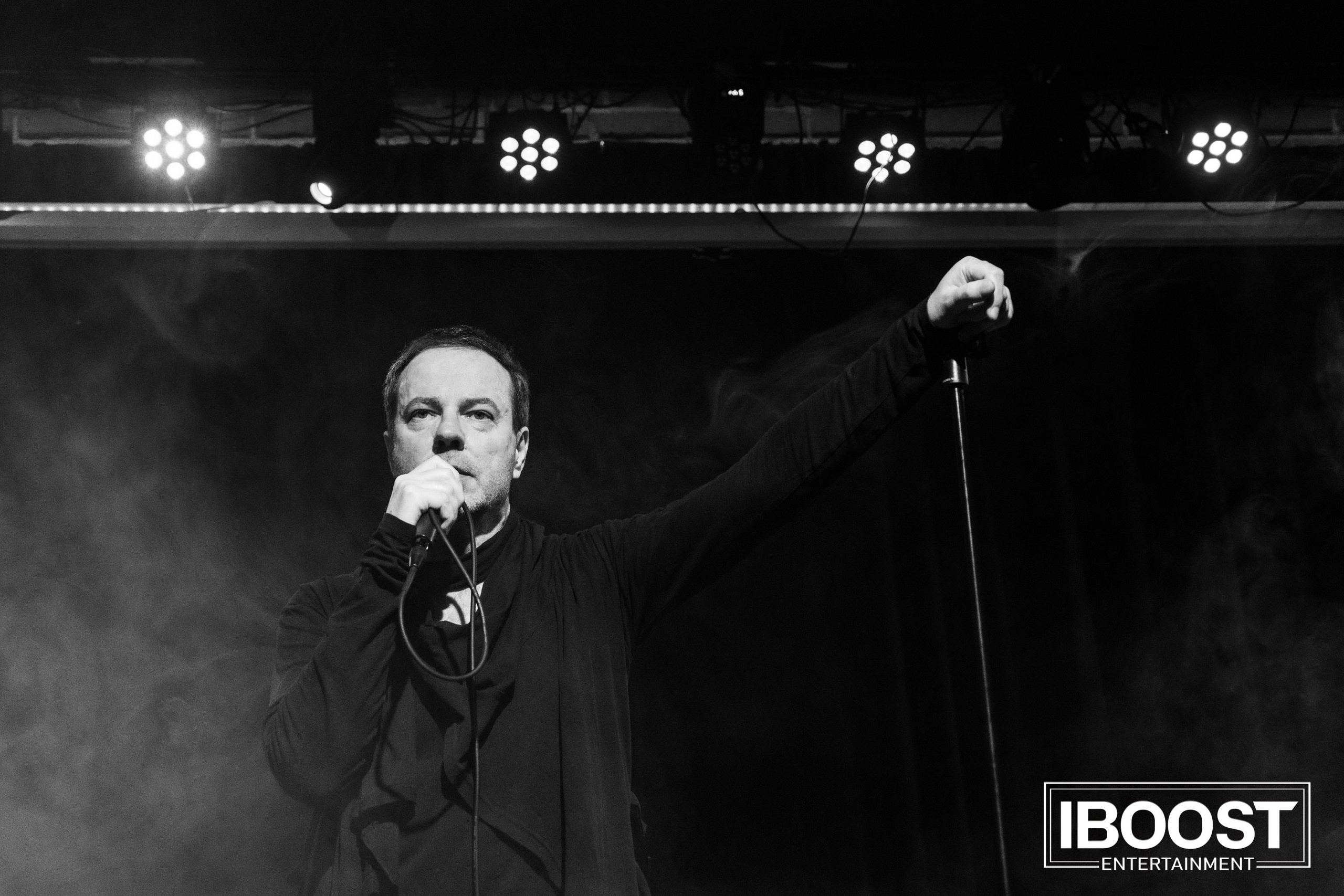 Black-and-white concert photo of the lead vocalist of Animal JazZ pointing toward the audience on stage.