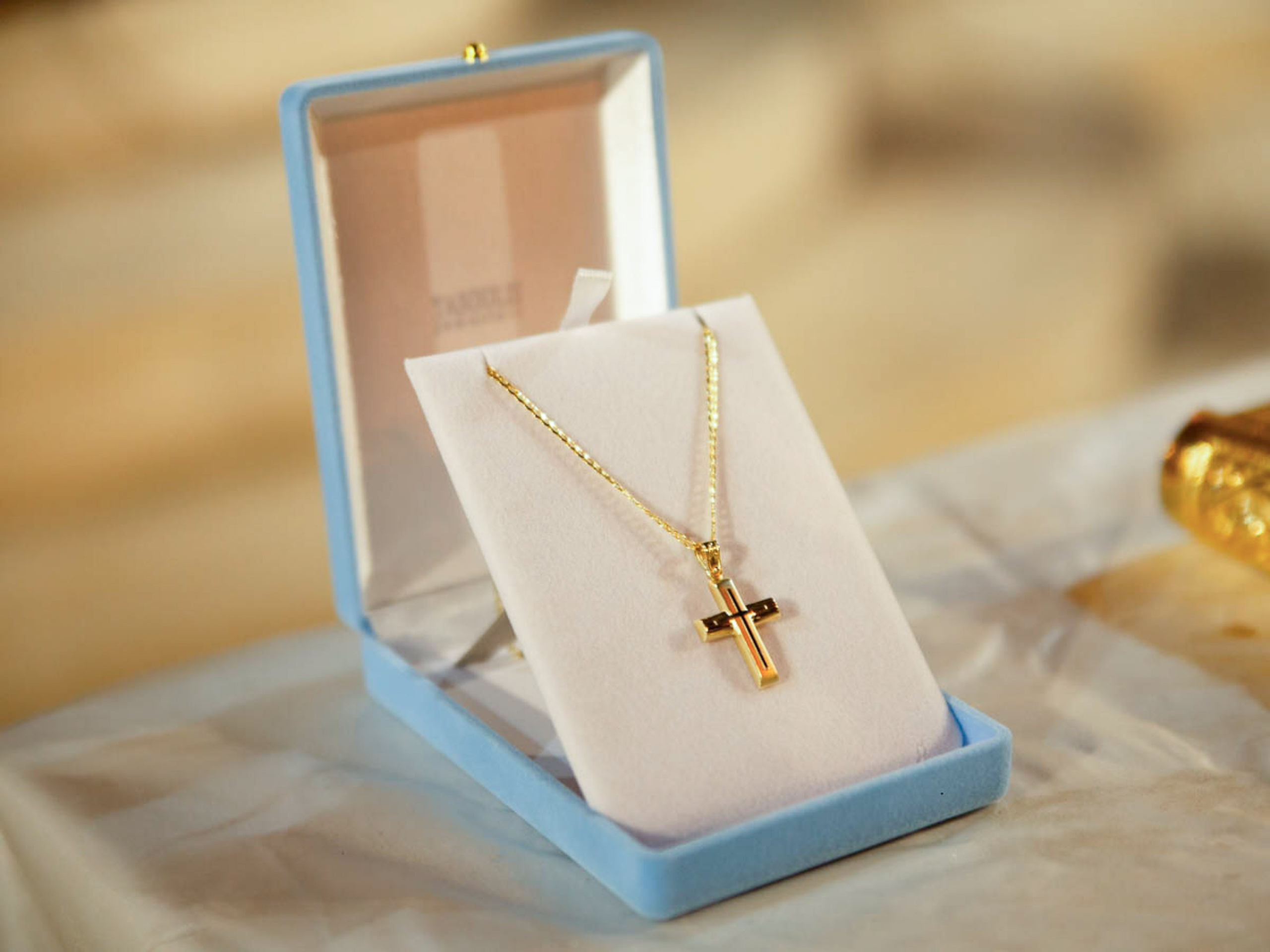 Gold baptism cross in a gift box before the ceremony