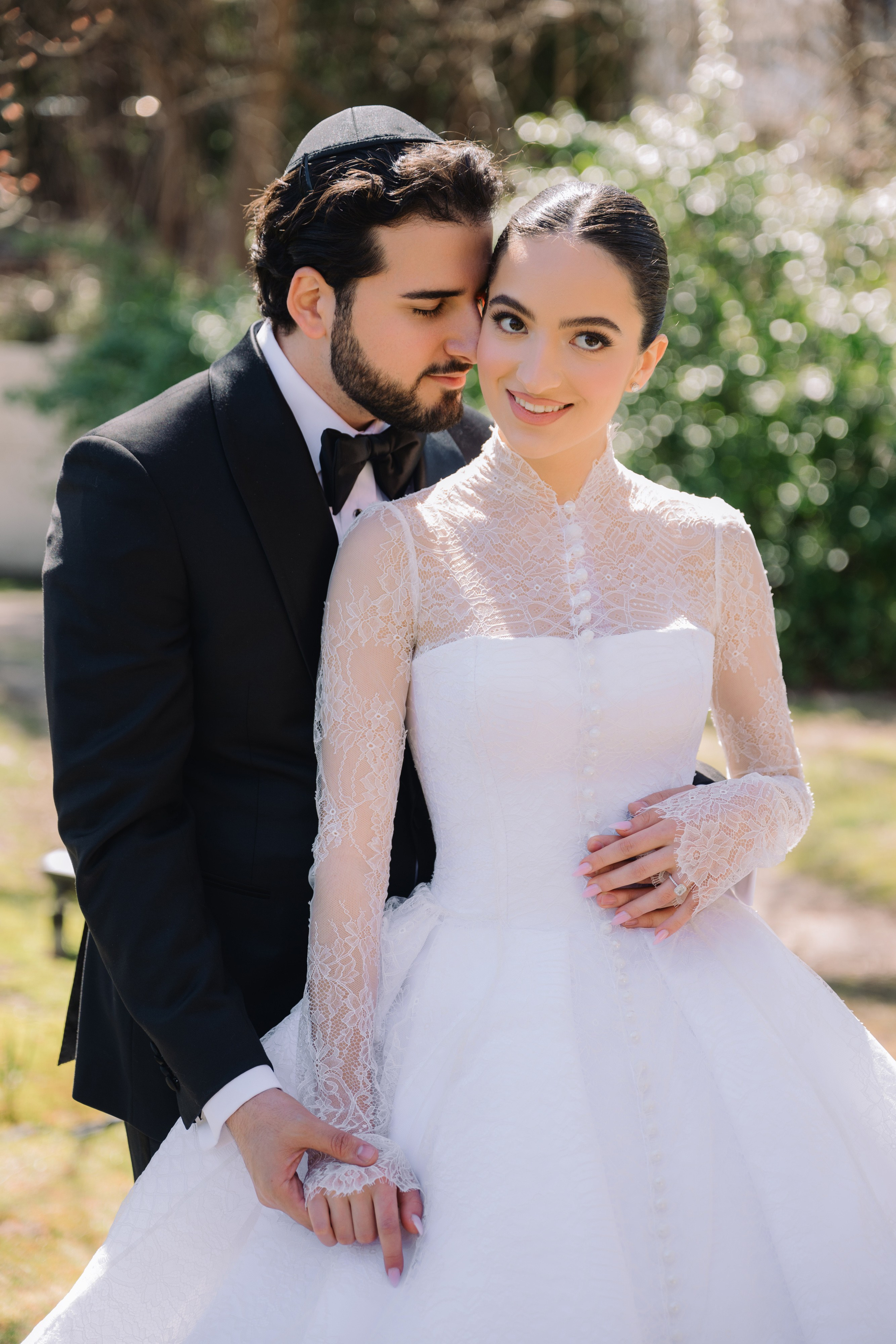 a bride and groom pose for a photo in the park