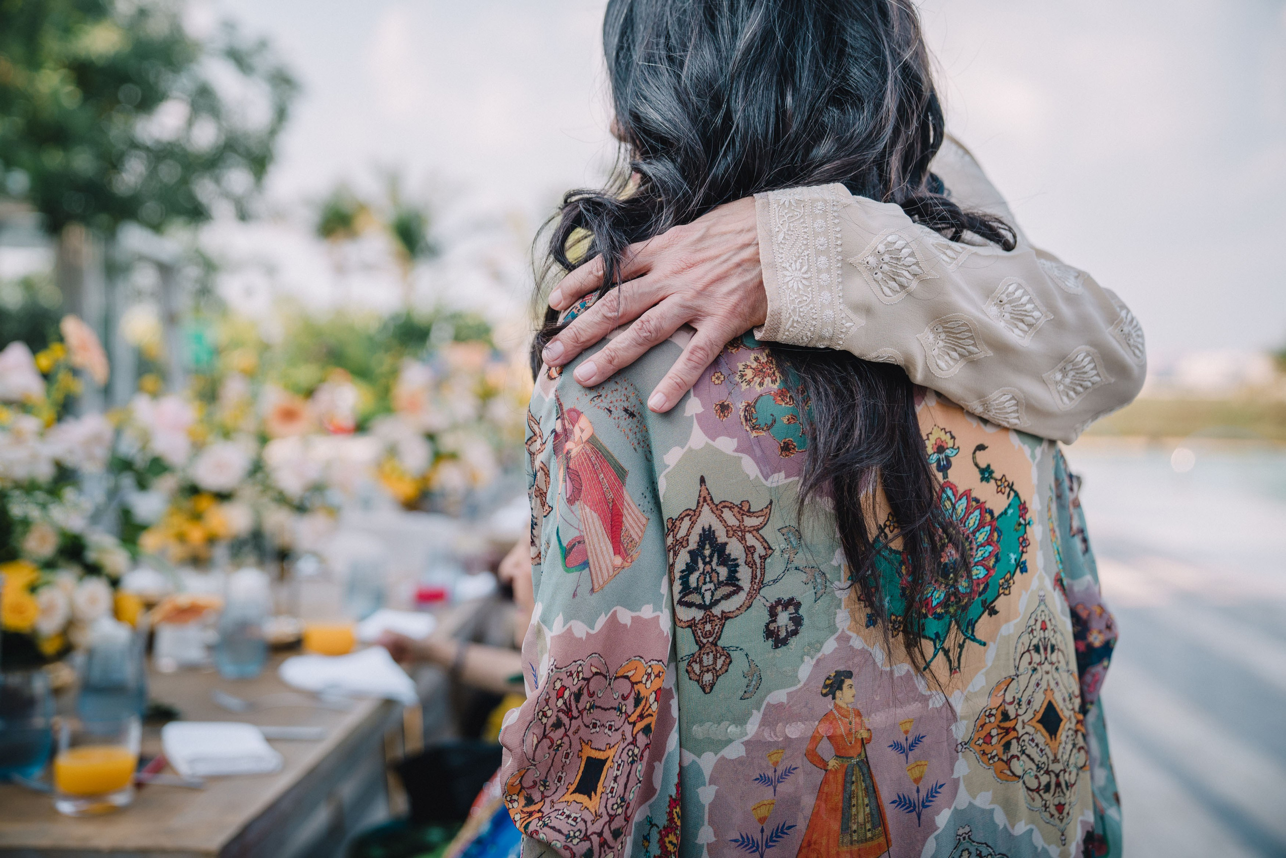 a man is hugging a lady in a colorful indian sari