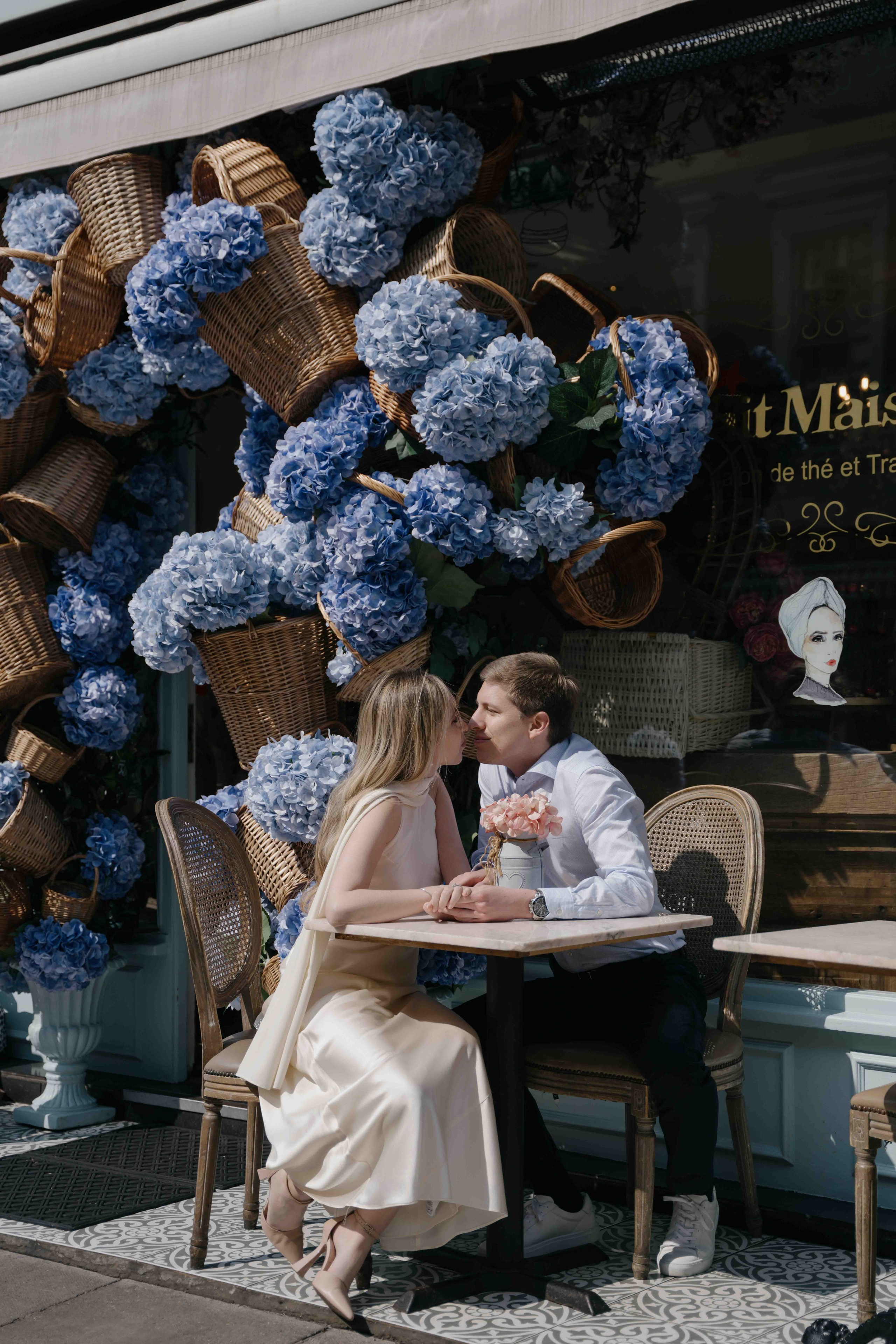 Couple enjoying a relaxed moment in a South Kensington cafe during engagement photoshoot