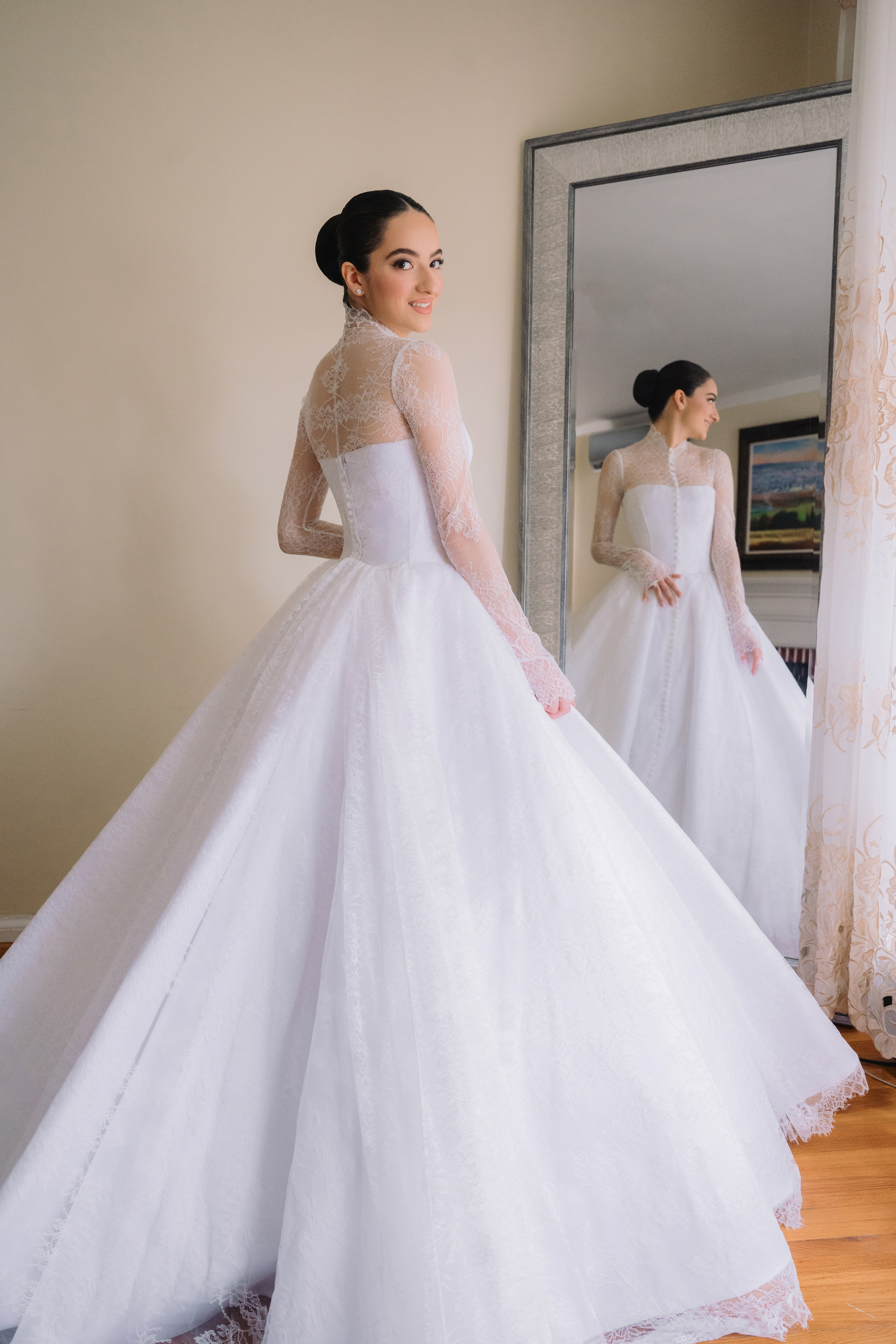 a bride in her wedding dress looking at herself