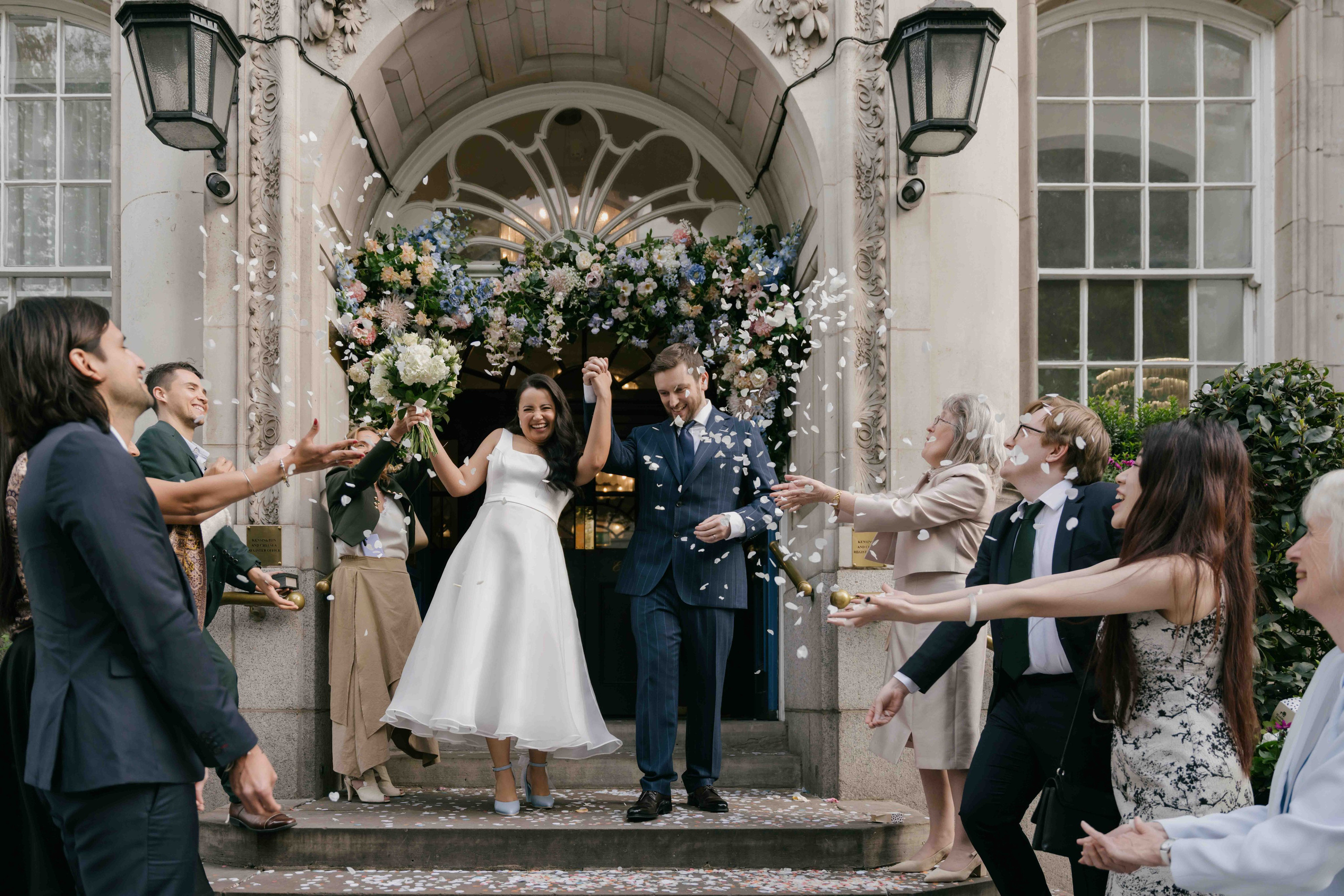 Chelsea Town Hall wedding confetti moment London, bride and groom exiting ceremony, iconic just married moment, elegant documentary wedding photography