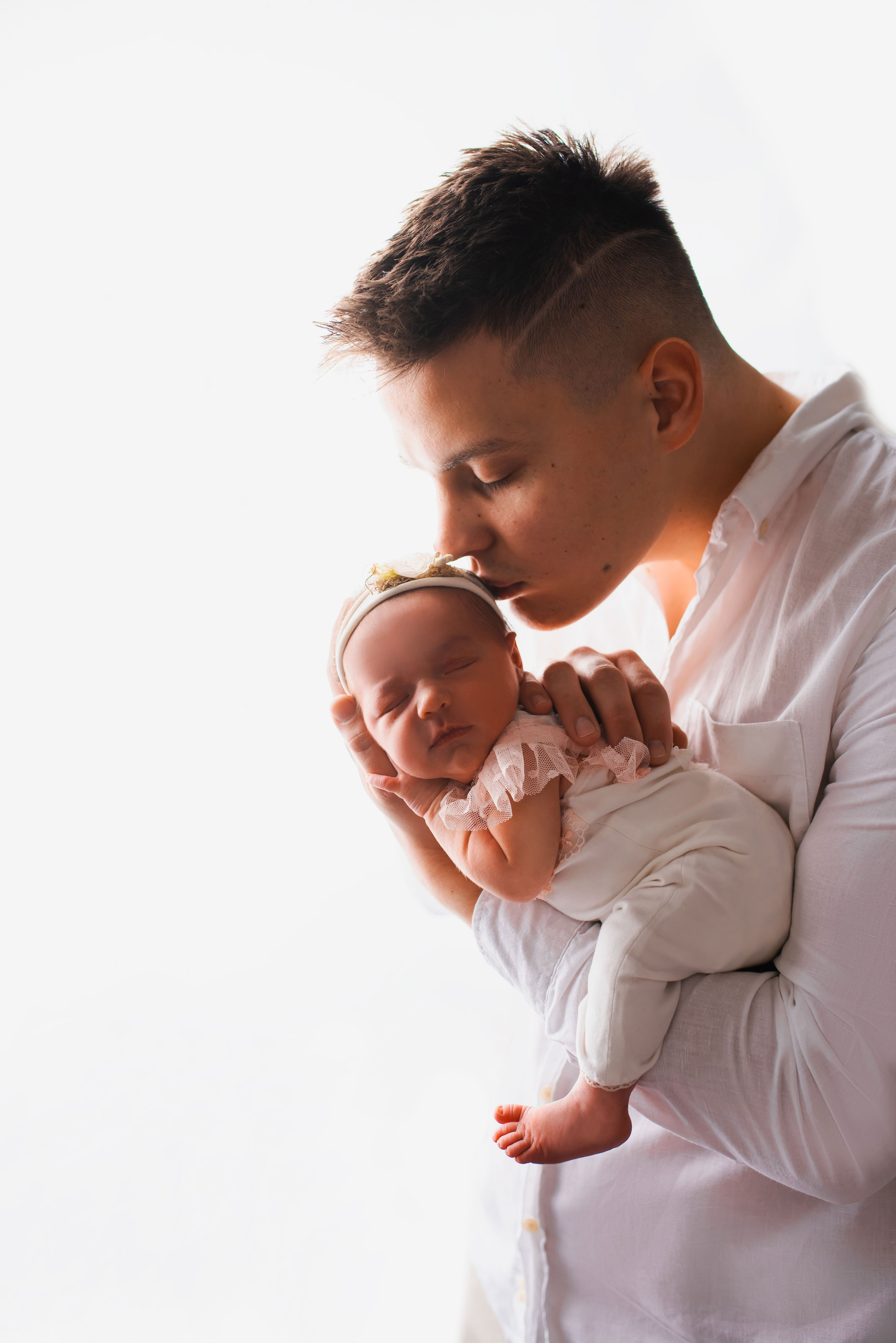 Father holding his newborn baby during a newborn photography session in Prague