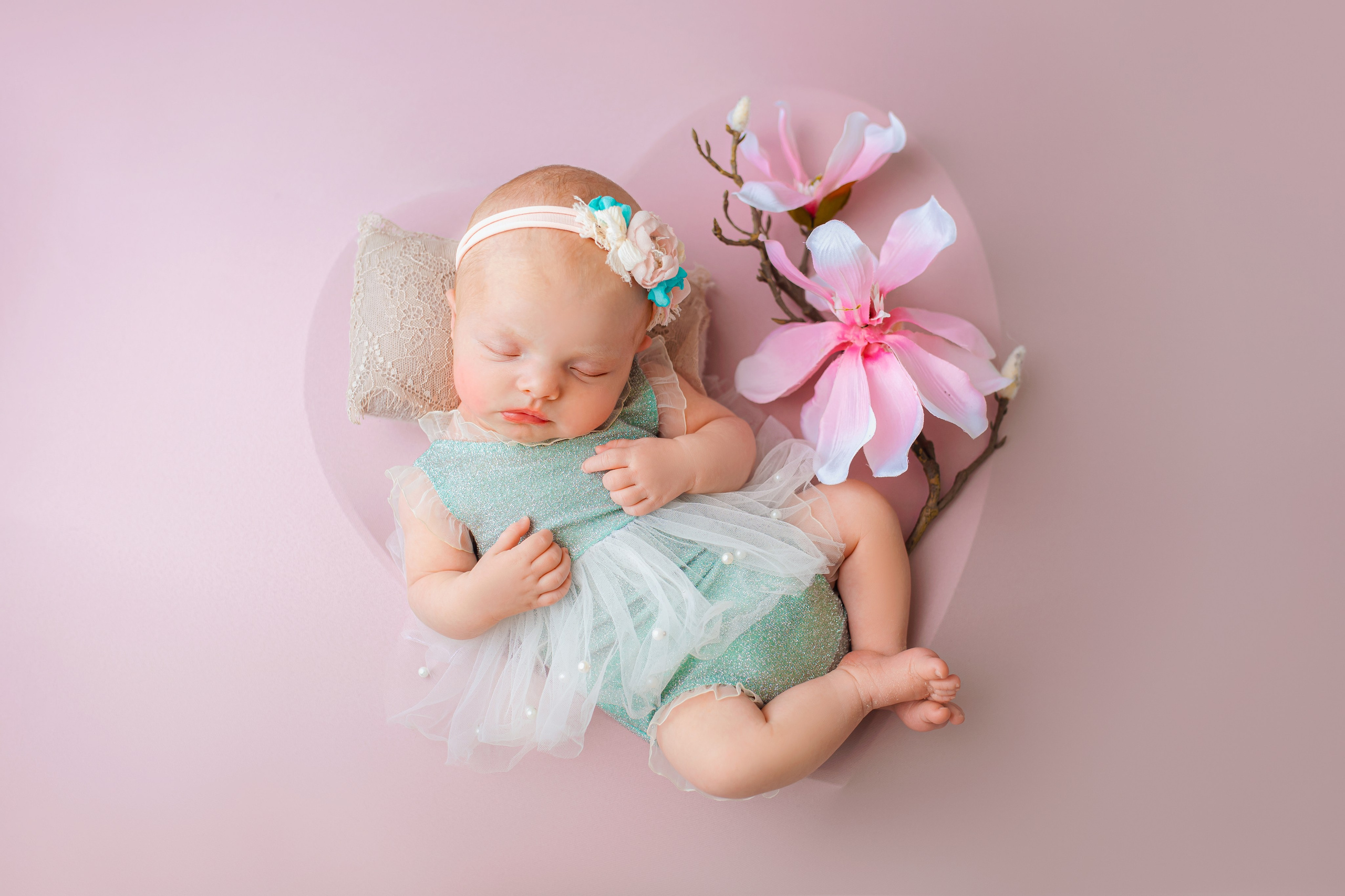 Newborn baby girl in a floral setup photographed in a Prague newborn studio