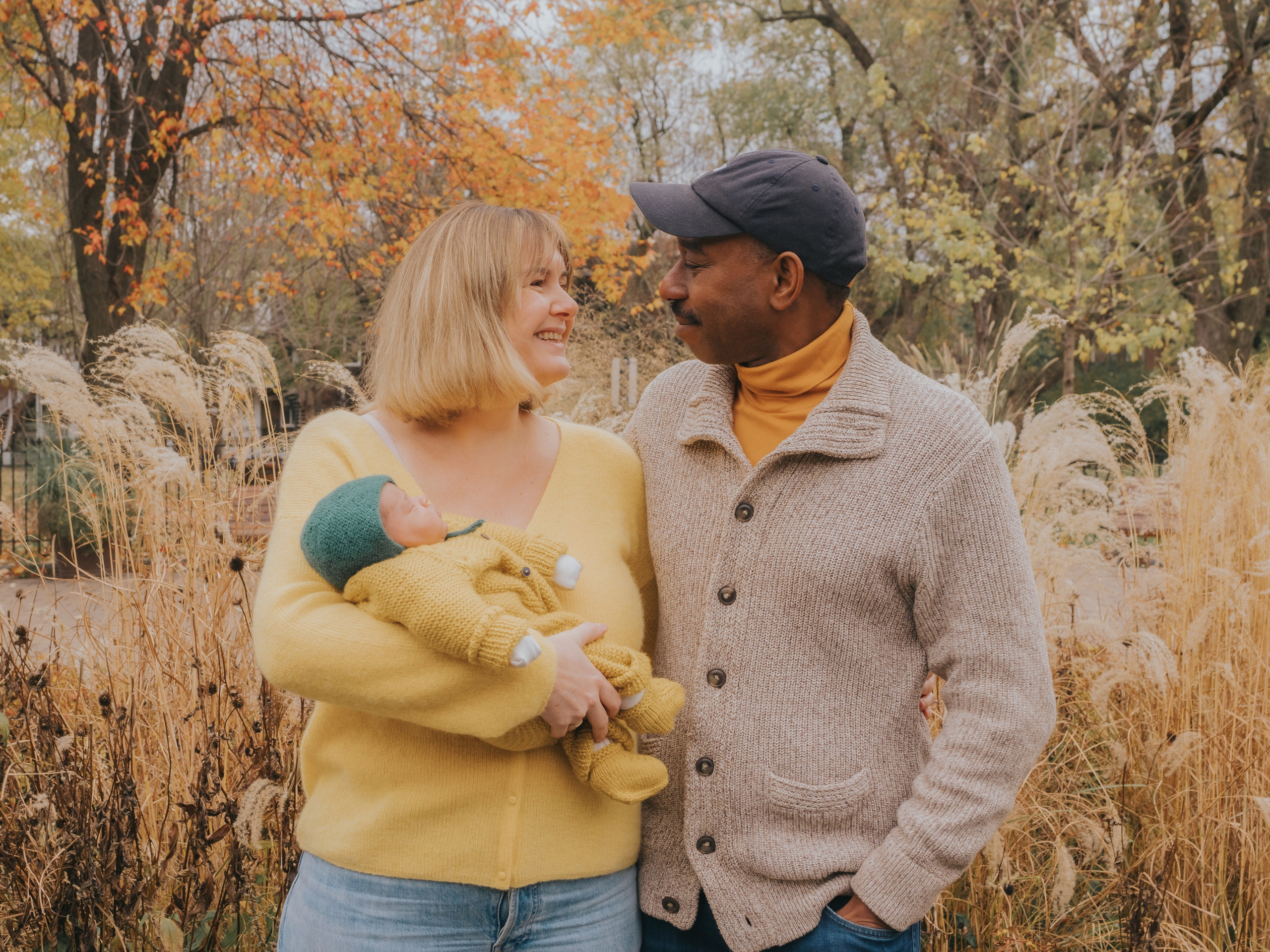 Couple in nature setting with newborn in arm.