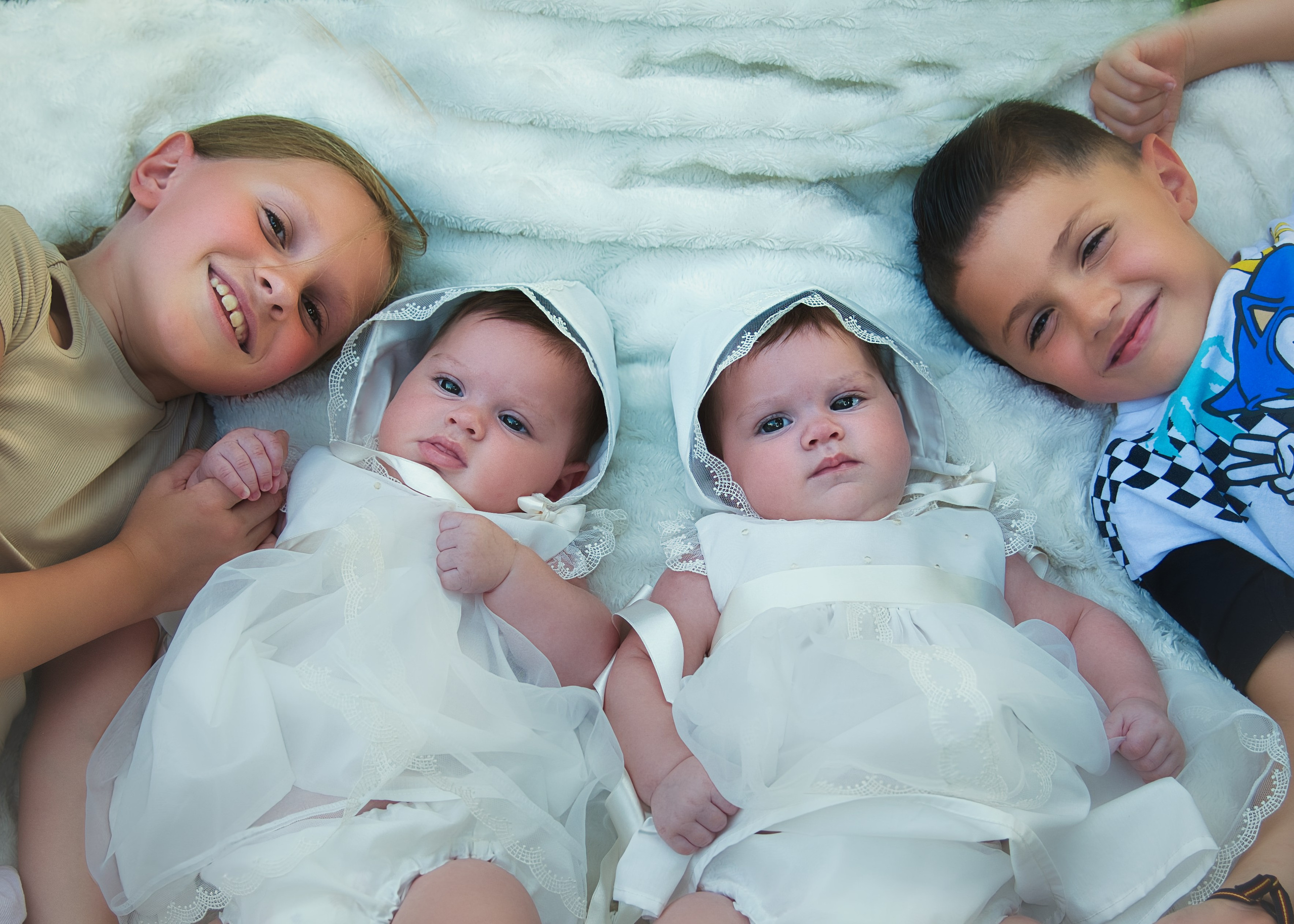 Niña con su vestido de bautizo blanco sonriendo dulcemente.