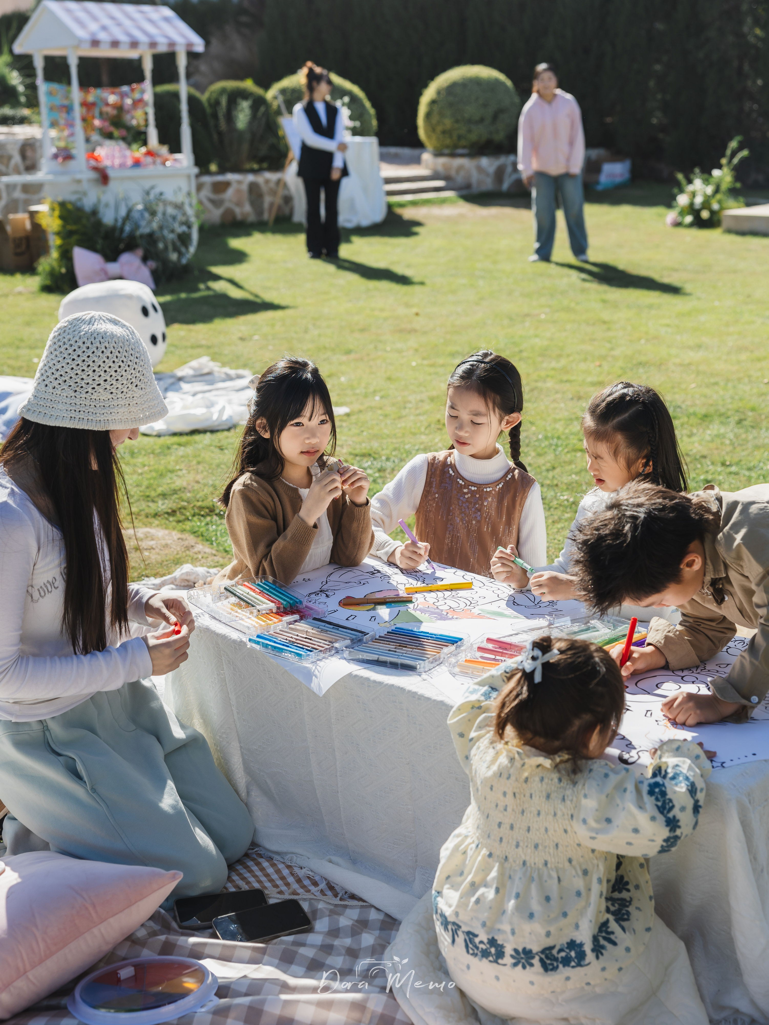 Shanghai family photographer documenting a 6th birthday party - children doing crafts together at outdoor celebration