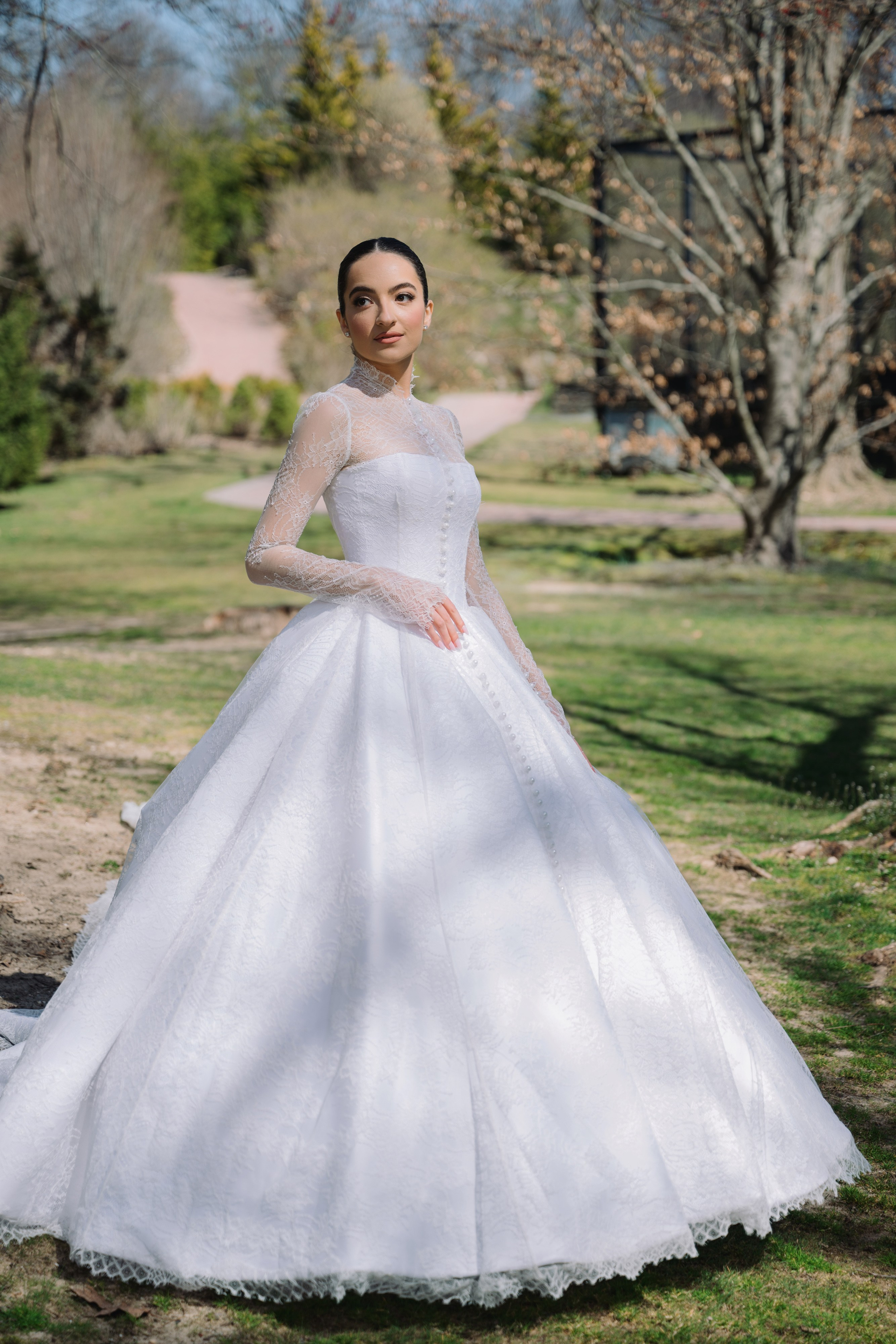 a woman in a white wedding dress standing in the grass