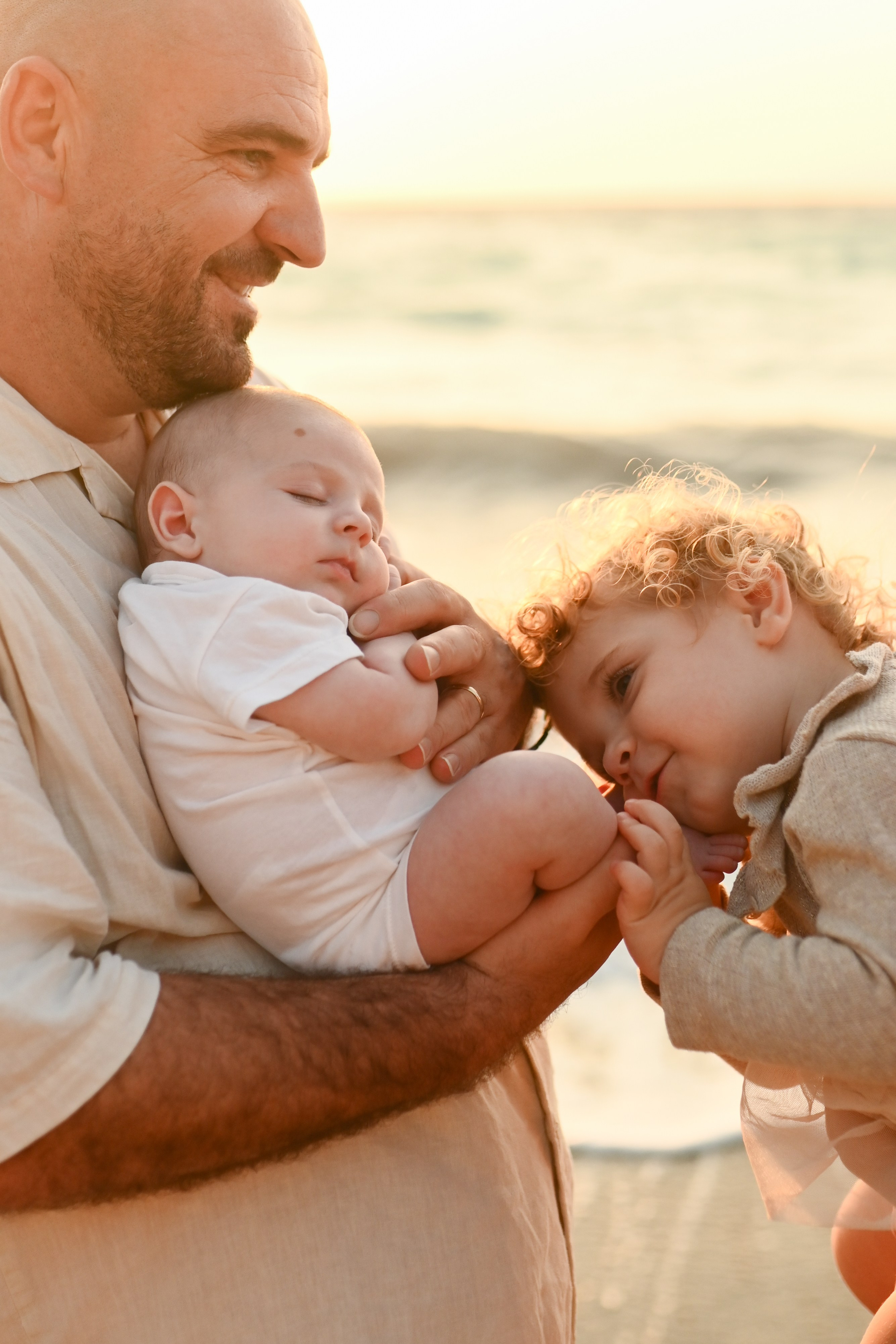 Happy family walking along a Rhodes beach at sunset. Photographer in Rhodes Island