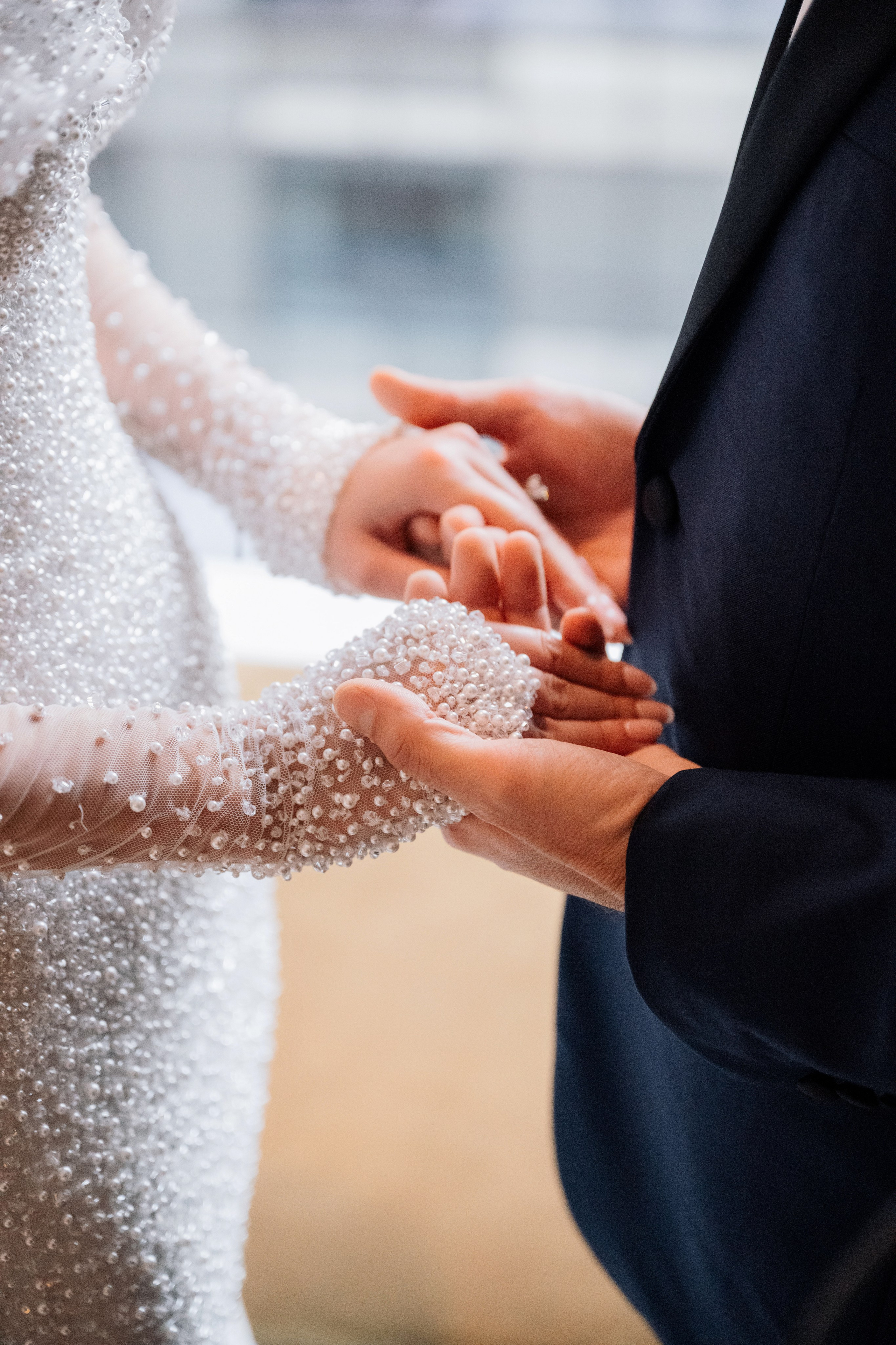 a bride and groom holding hands while they are getting married