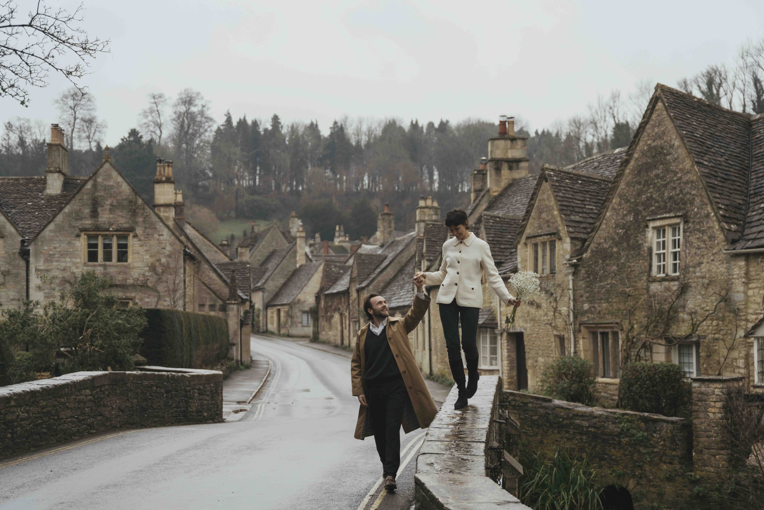 wide view of Castle Combe village in Cotswolds with historic stone houses engagement photoshoot setting