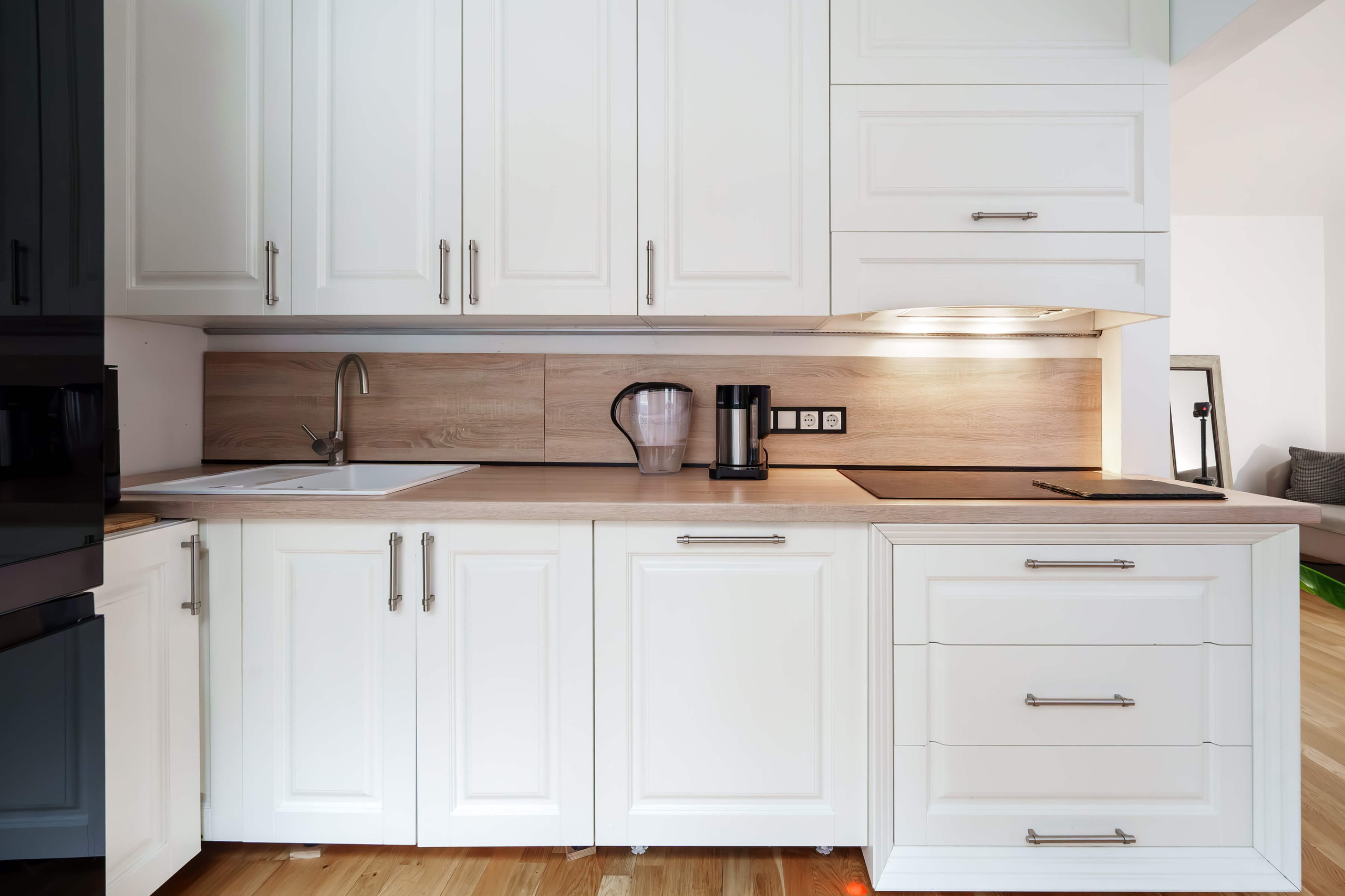 Svetainės zona su virtuve: šilta atmosfera, kokybiškos medžiagos ir daug erdvės kvėpuoti