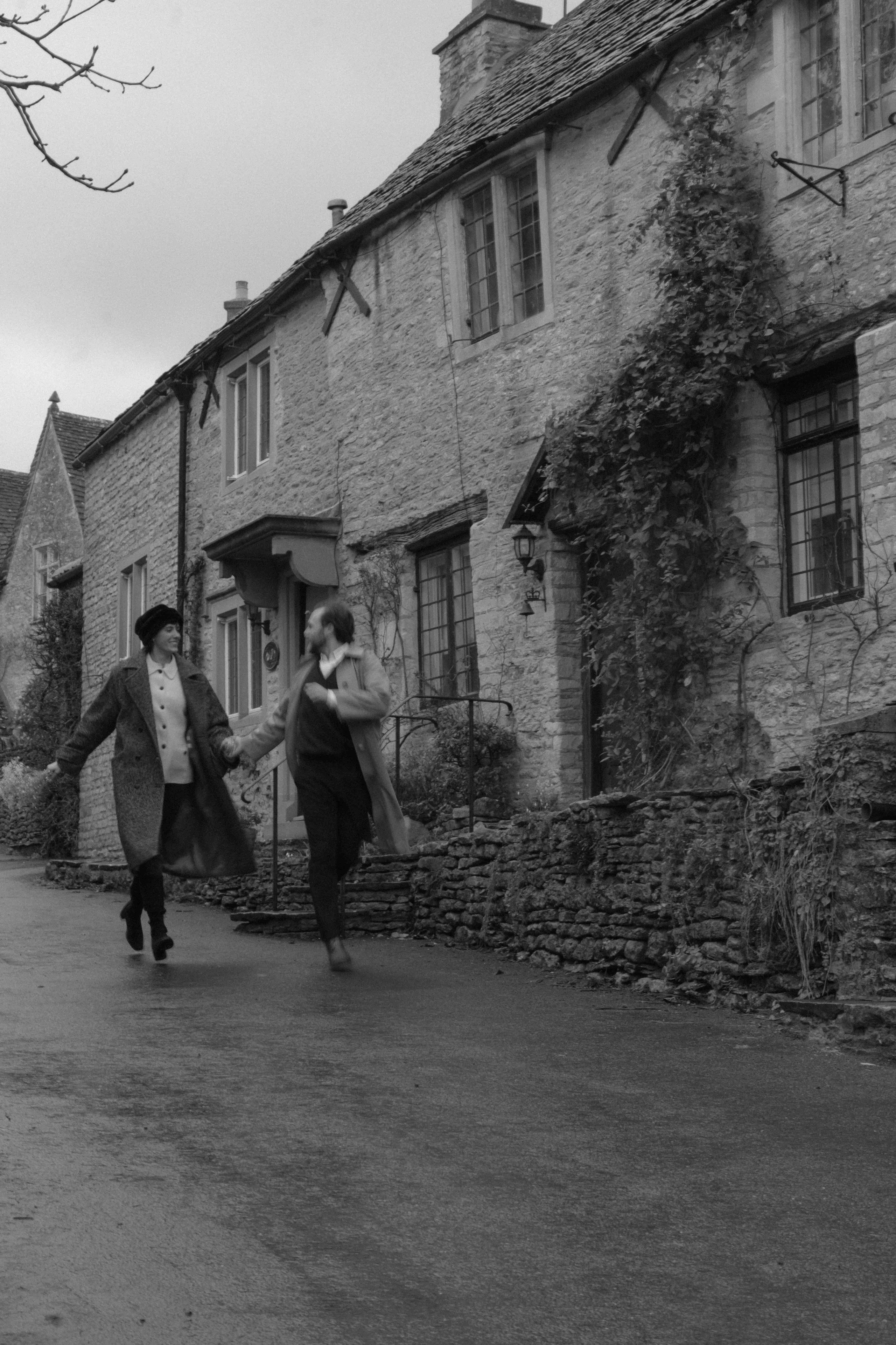 cinematic movement of couple in rain with natural blur in Castle Combe engagement session
