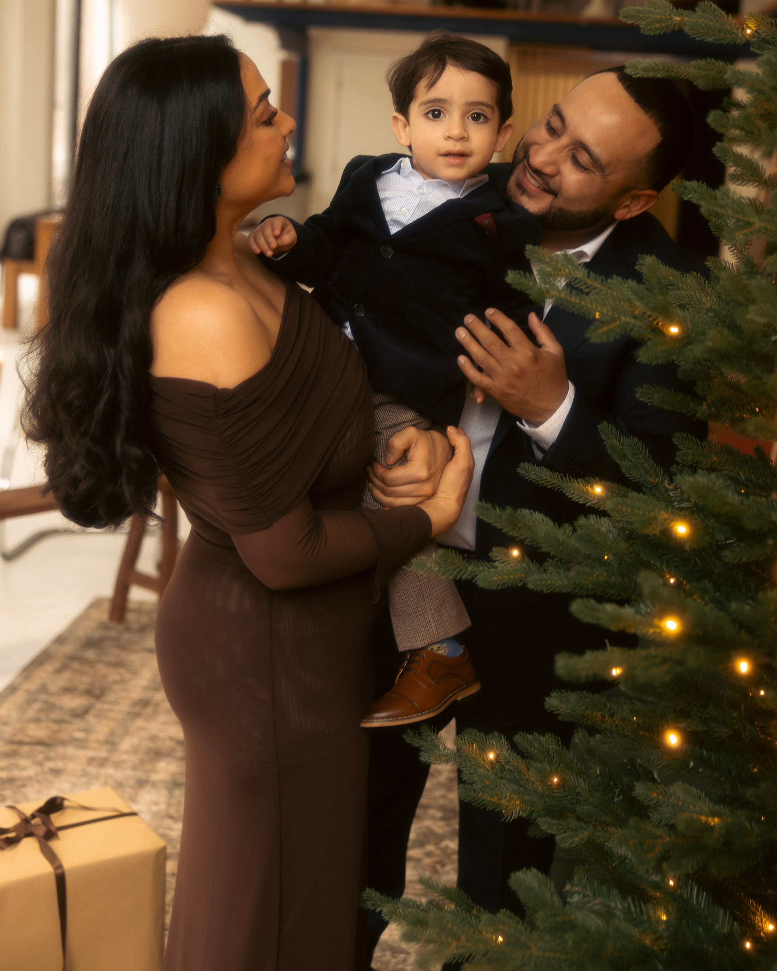 Parents holding newborn during soft holiday photoshoot